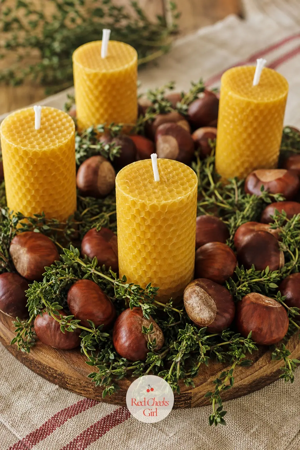 A Whole Roasted Chestnut and Fresh Thyme Ring Around Honey Candles — Whole chestnuts in their shell, still with that papery brown shine, ring a small wood base