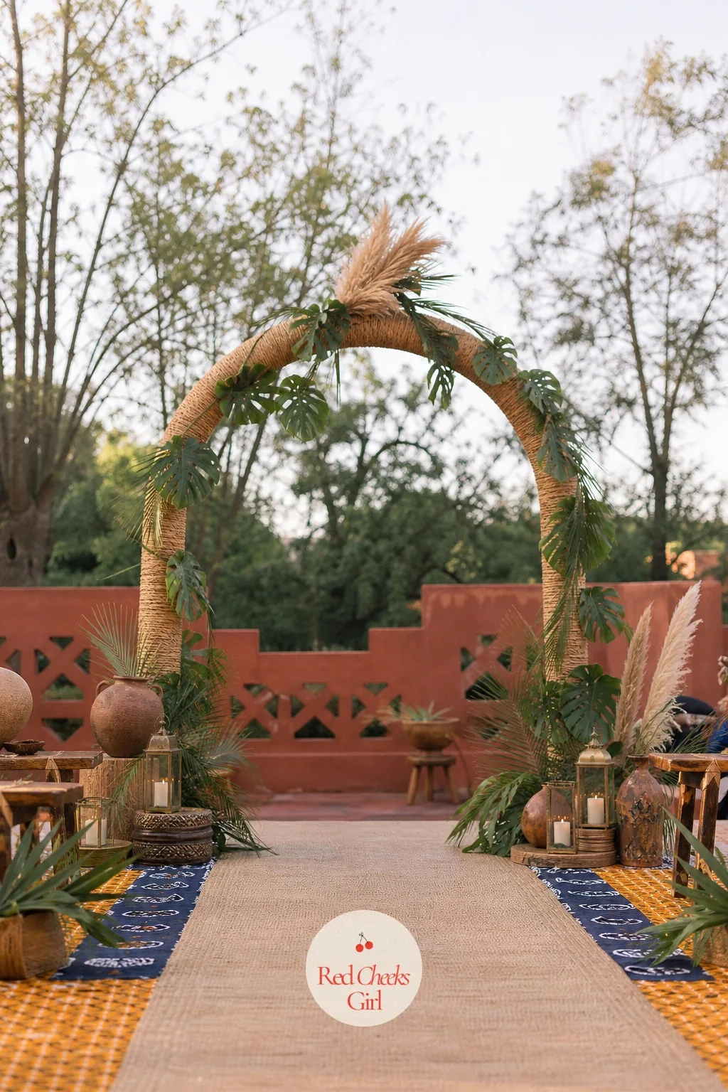 Rattan Arch Threaded With Raffia and Greenery — This is the shape you stand under, and it should feel woven rather than built: rattan poles bent into an arch