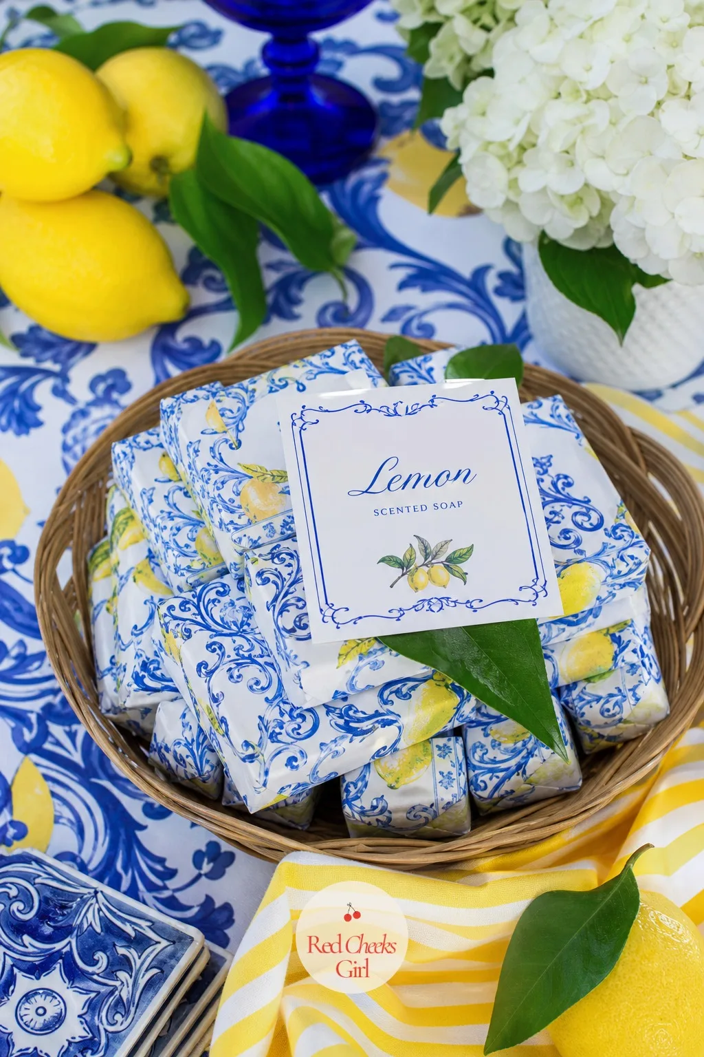 Lemon Soap Favor Bars — Small bars of lemon scented soap wrapped in simple paper stack neatly inside a shallow basket by the door. Amalfi coast baby shower