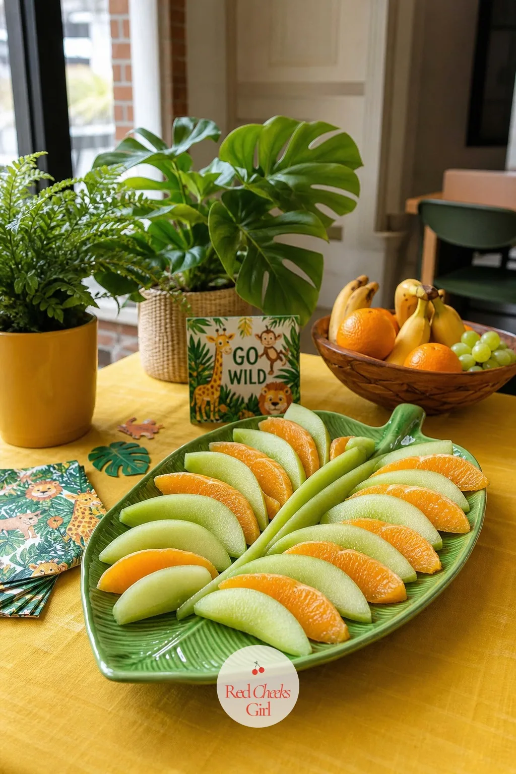 Jungle Leaf Fruit Platter — Melon and orange segments look like an afterthought piled in a bowl. Animal themed birthday party