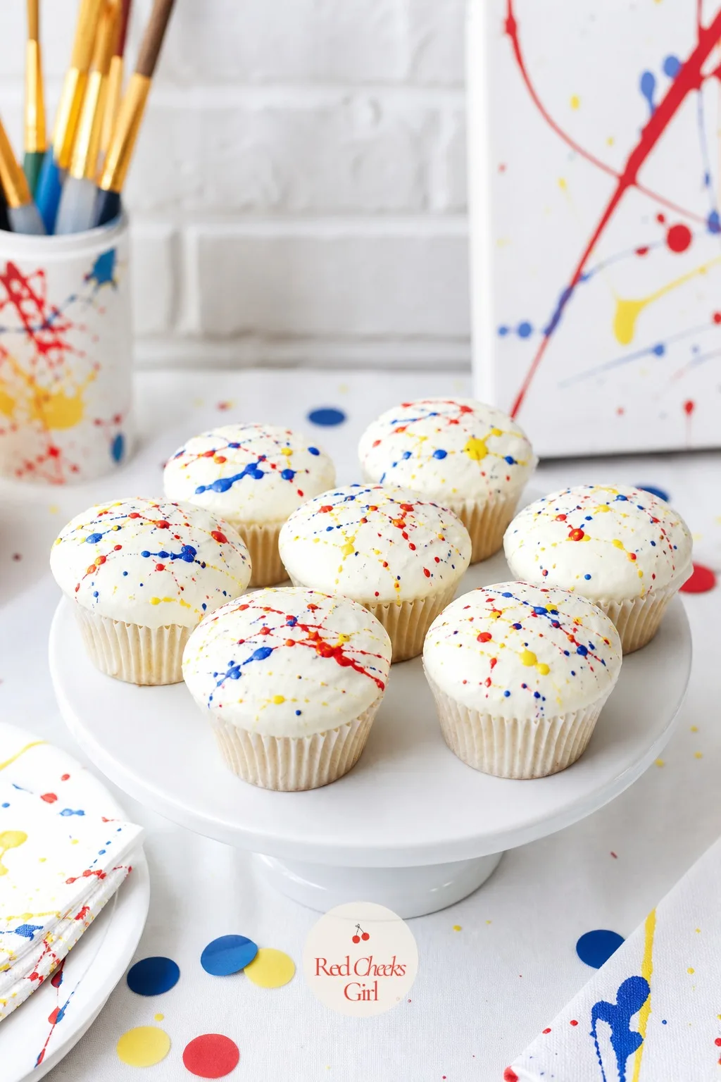 Rainbow Splatter Cupcakes — Plain vanilla cupcakes get iced white, then flicked with three or four colors of very thin glaze using a spoon or an old
