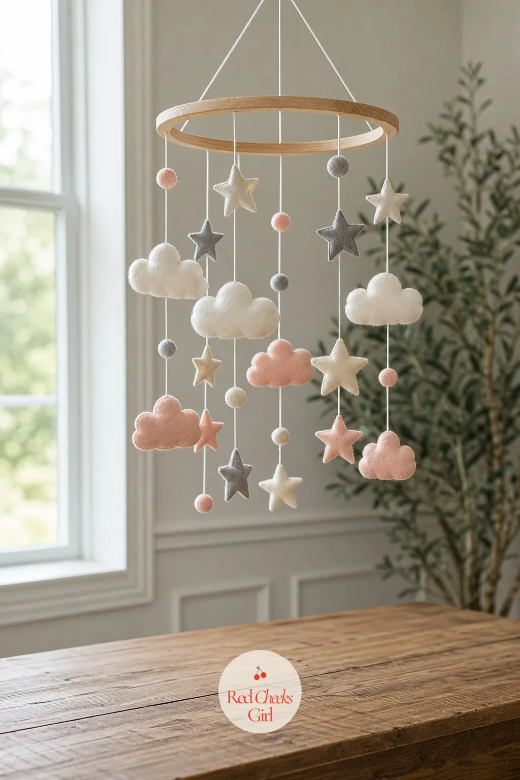 Crib Mobile Hung Over the Table — Instead of sitting on the table, this one hangs above it: a pastel cloud and star mobile suspended from a wooden ring on
