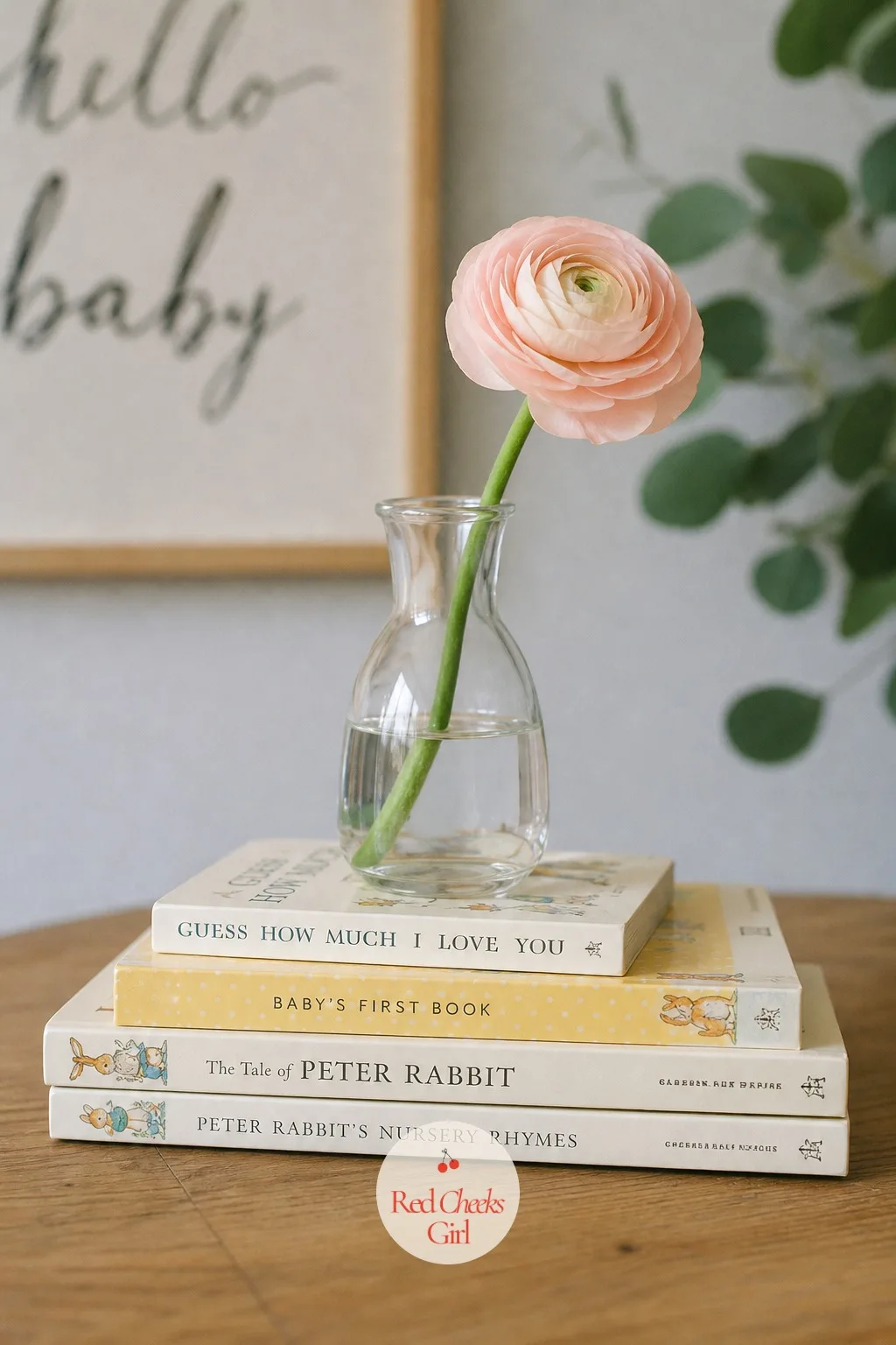 Stacked Board Books With a Bud Vase — A pile of board books looks like clutter until one small vase sits on top of it, and then it reads as styled. Baby shower