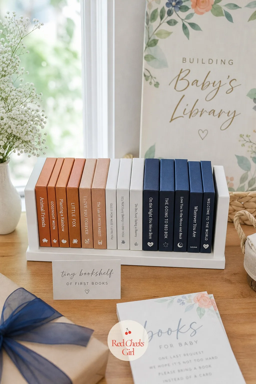 Tiny Bookshelf of First Books — A miniature white shelf, the kind made for a nursery wall, sits flat on the table instead of mounted, and a handful of books