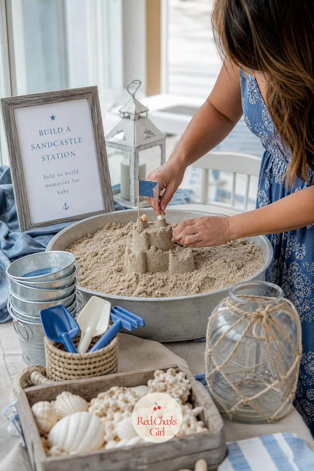 Build a Sandcastle Station — A low table holds a few shallow trays of damp craft sand, a stack of small metal or plastic buckets in different sizes, mini
