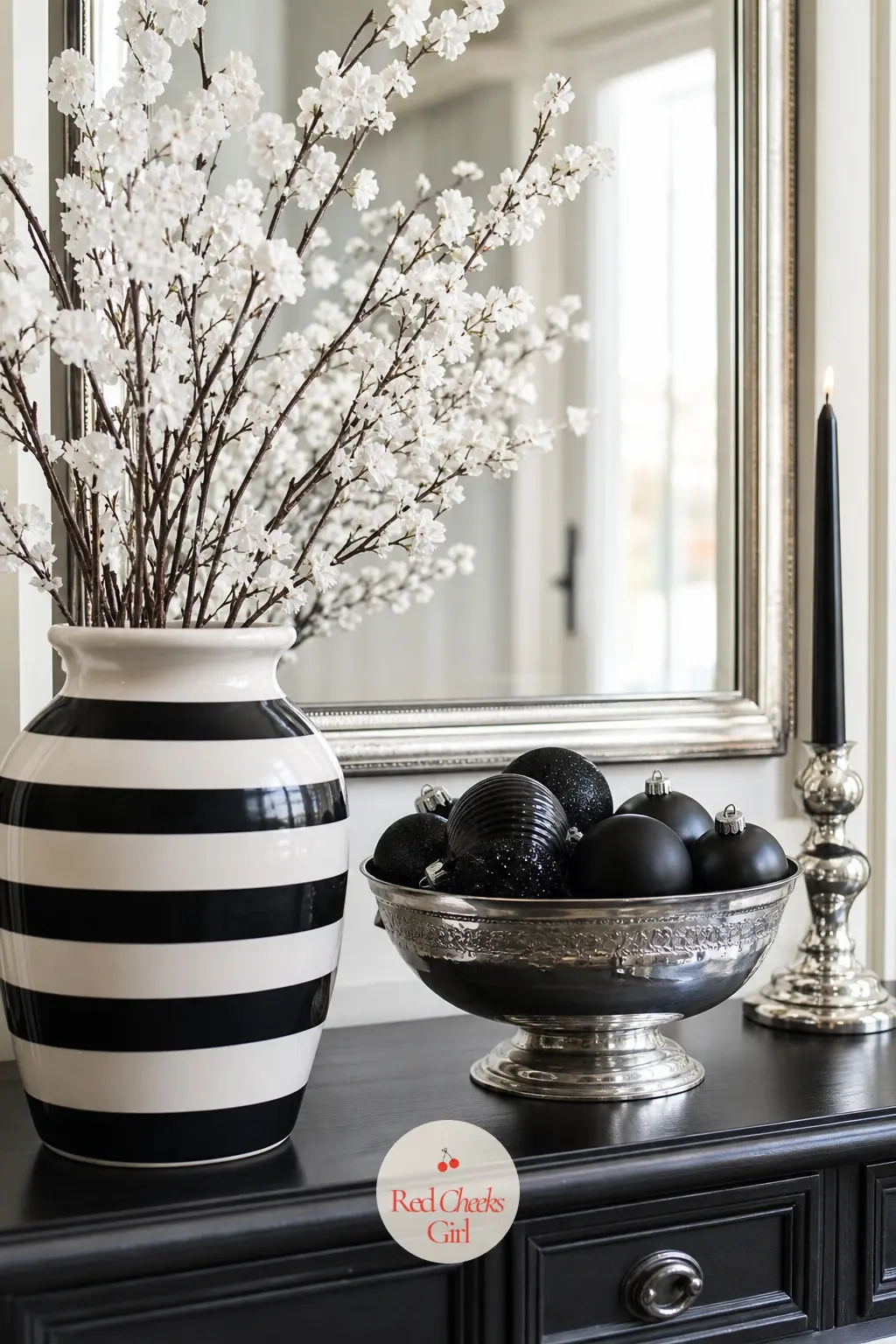 The Console Table, Set With a Striped Vase and Silver Bowl — The entry console gets a still life rather than a scatter of objects: one striped vase holding
