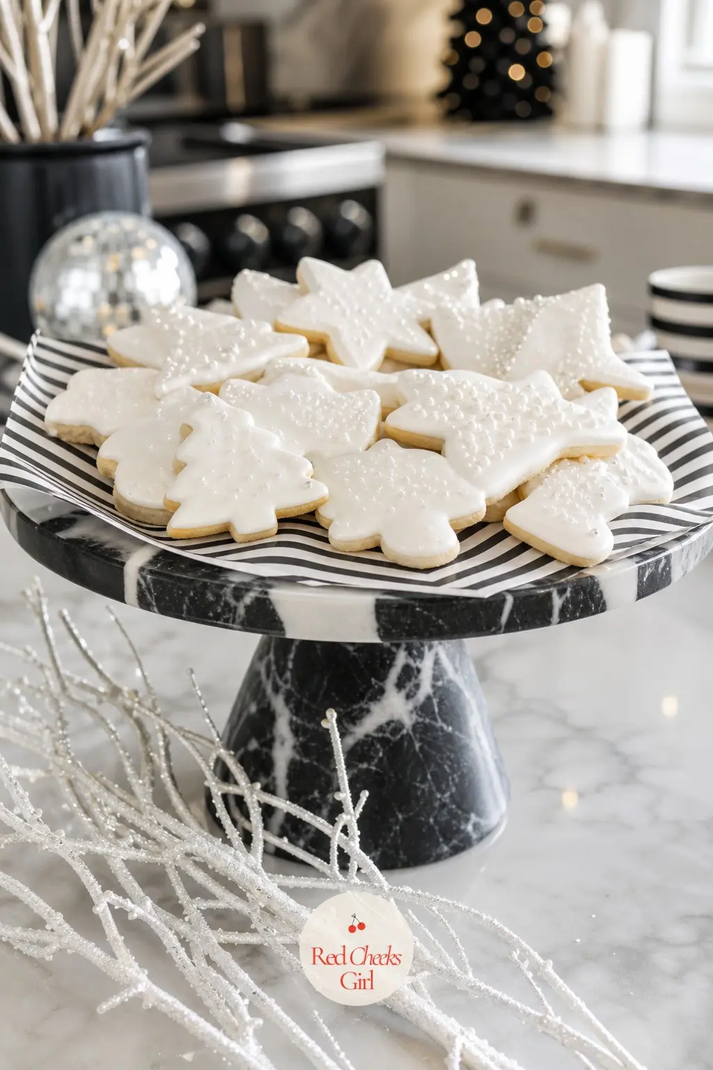 The Kitchen Island, Set With a Tray of Monochrome Treats — The kitchen island gets one tray rather than a spread: a black and white marble cake stand holding