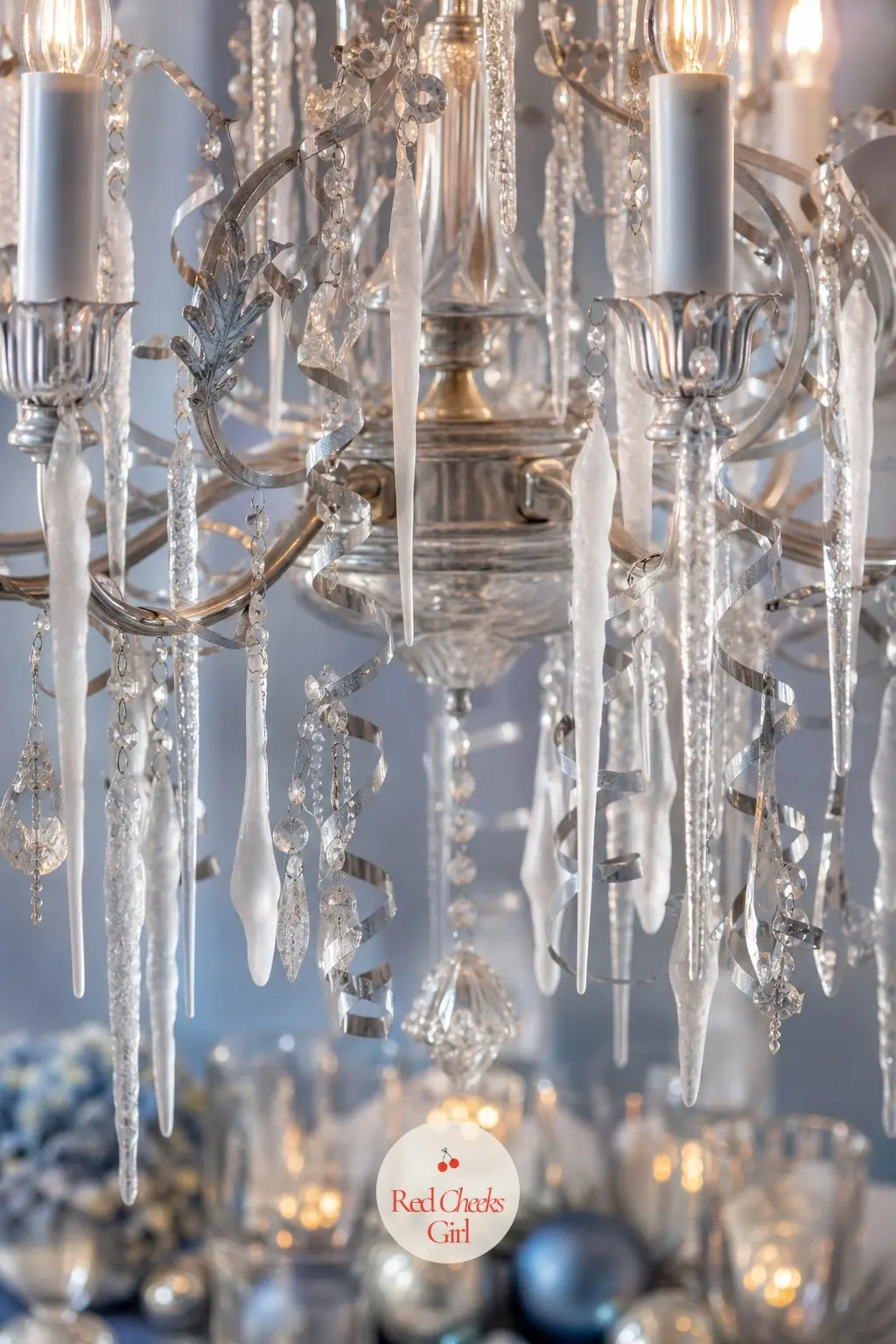 The Chandelier, Trimmed in Frosted Glass and Silver — The existing fixture gets hung with faux icicle drops and streamers of silver ribbon, catching every