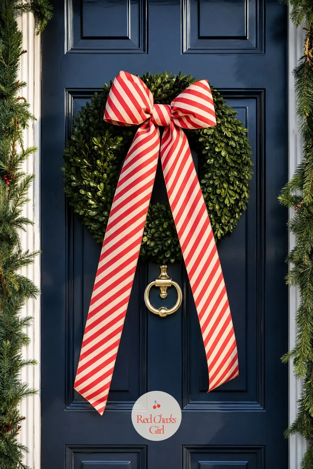 The Front Door, Hung With a Striped Bow Wreath — A plain boxwood wreath hangs on the door, but the real decoration is the bow: a wide candy-striped ribbon tied