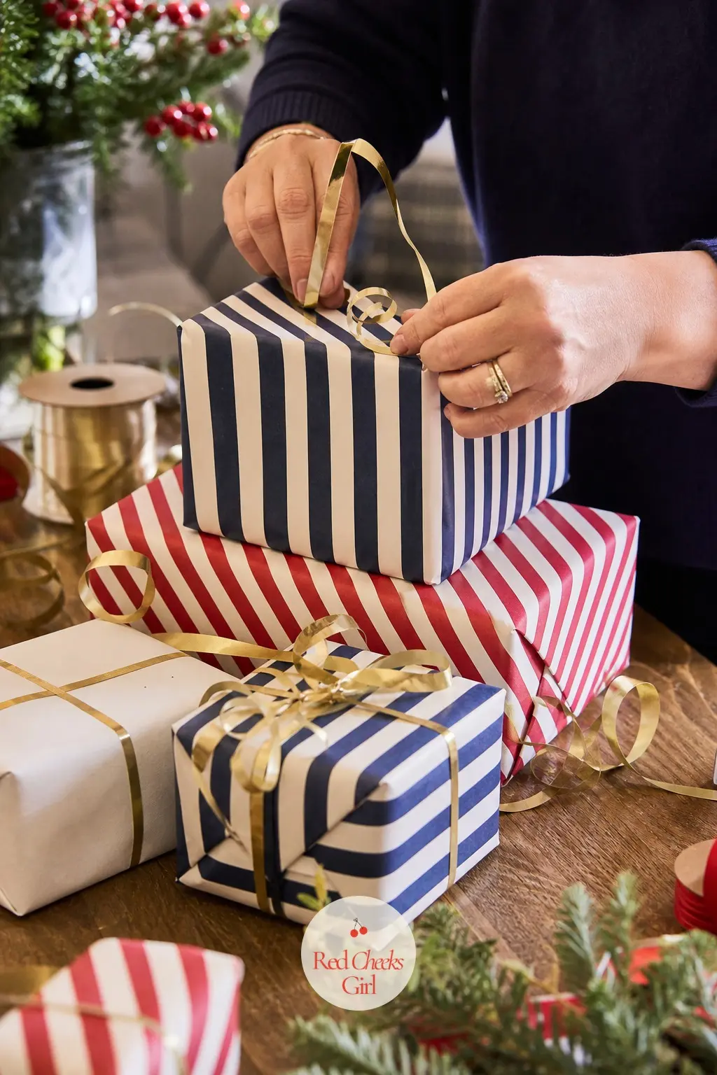 The Gift Wrapping Station, Papered in 2 Rolls of Candy-Stripe Paper — Two rolls of candy-stripe wrapping paper in navy and cherry cover most of the pile