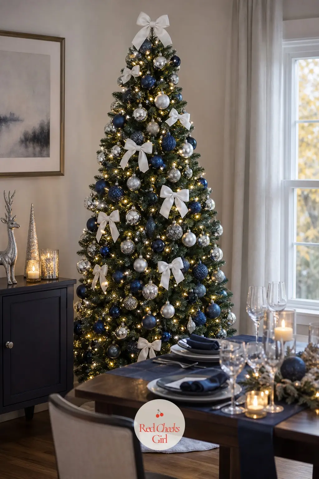 A Navy Tree Standing Sentinel by the Table — A full artificial tree positioned just behind the head of a set dining table, close enough that the baubles catch