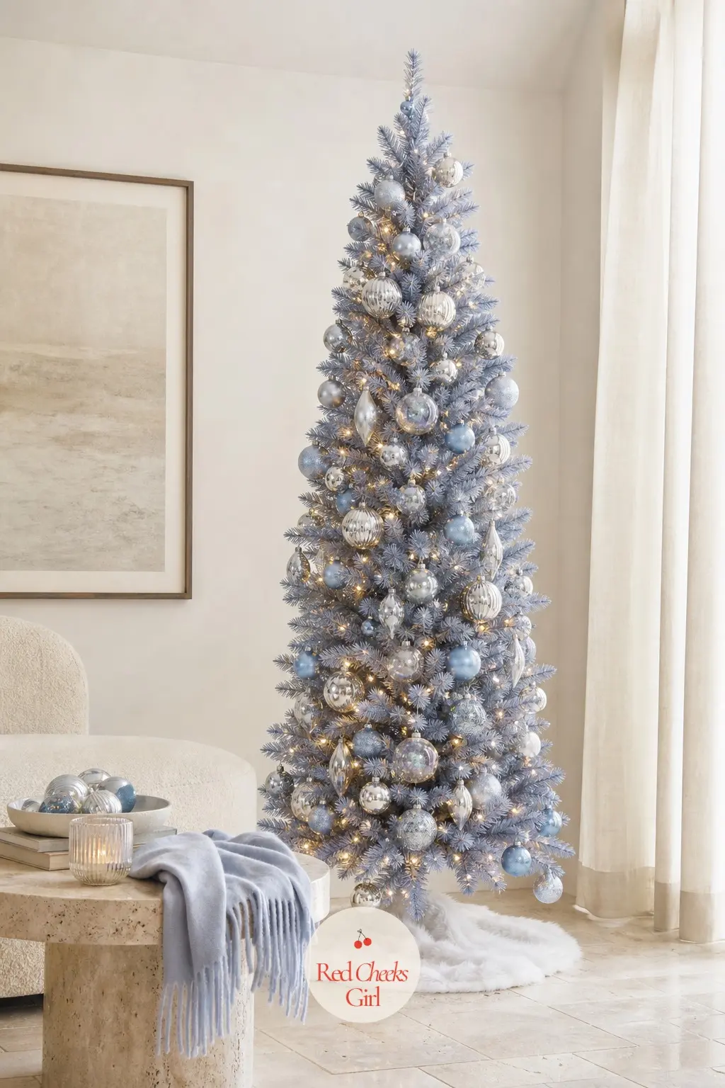 A Periwinkle Tree Over the Travertine Table — A slim artificial tree standing near a low travertine table and a folded cashmere throw, periwinkle blue paired