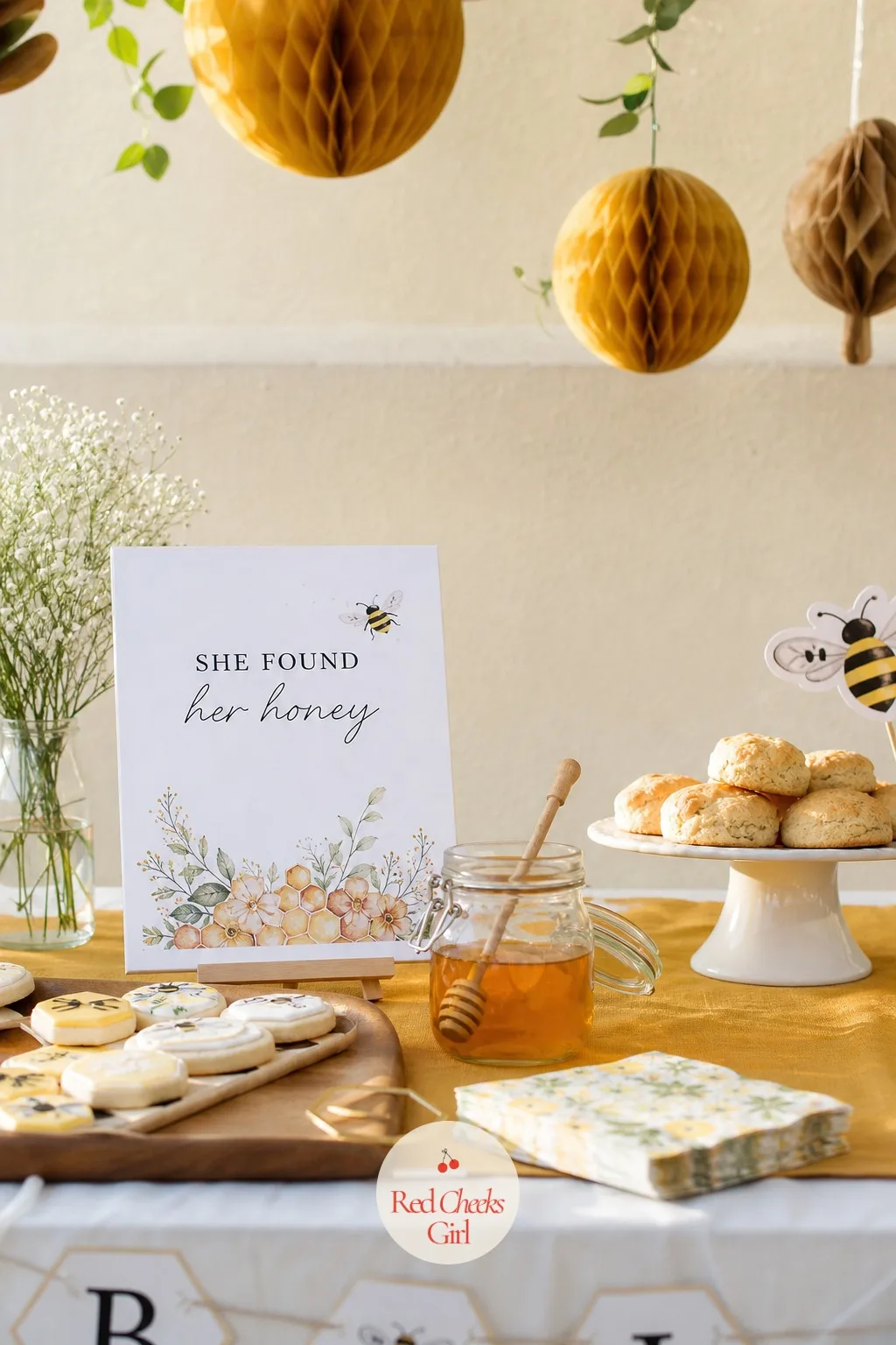 She Found Her Honey — Mustard and cream, honeycomb shapes cut from paper and hung in a loose cluster, a honey dipper left resting in a small jar at the centre
