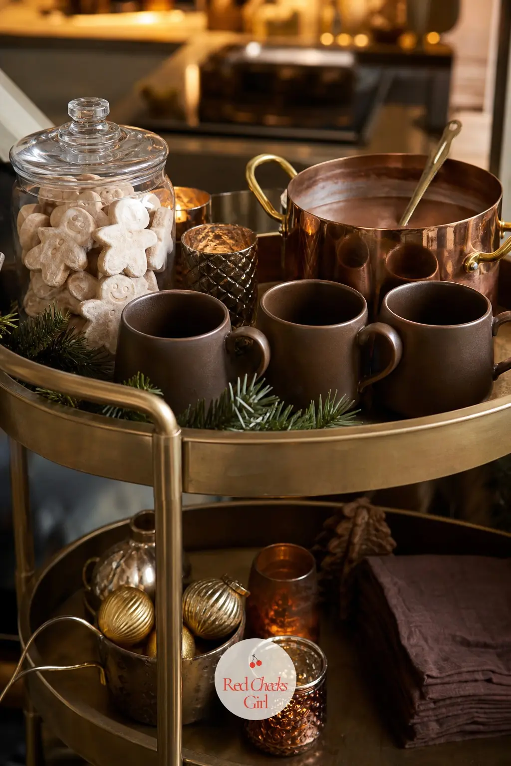The Drinks Cart, Poured with Caramel Hot Chocolate and Gingerbread Marshmallows — A small cart or sideboard holds a pot of hot chocolate, a row of bronze mugs