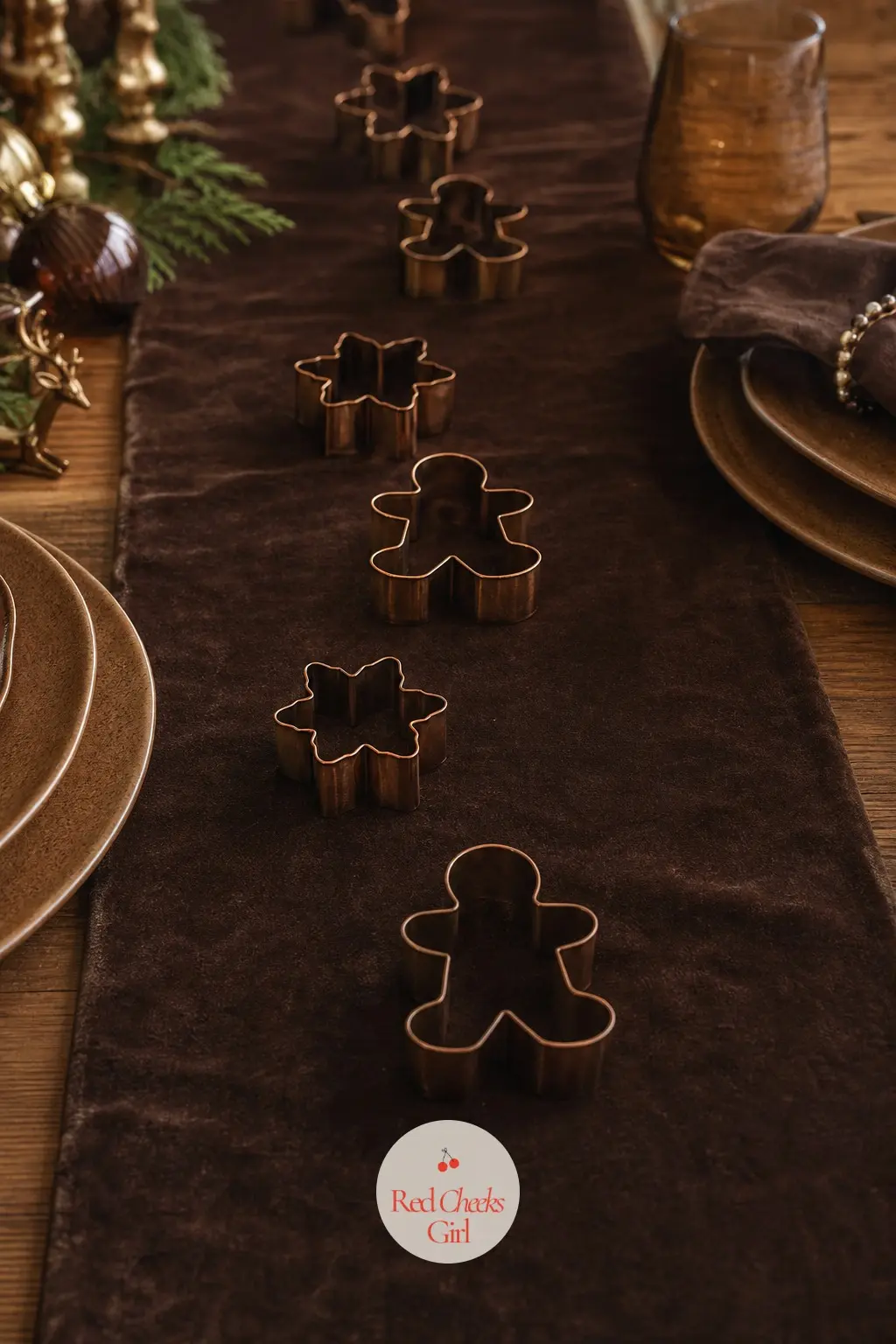 The Table Runner, Laid in Chocolate Velvet with a Trail of Bronze Gingerbread Cutters — A chocolate velvet runner down the centre of the table carries a trail