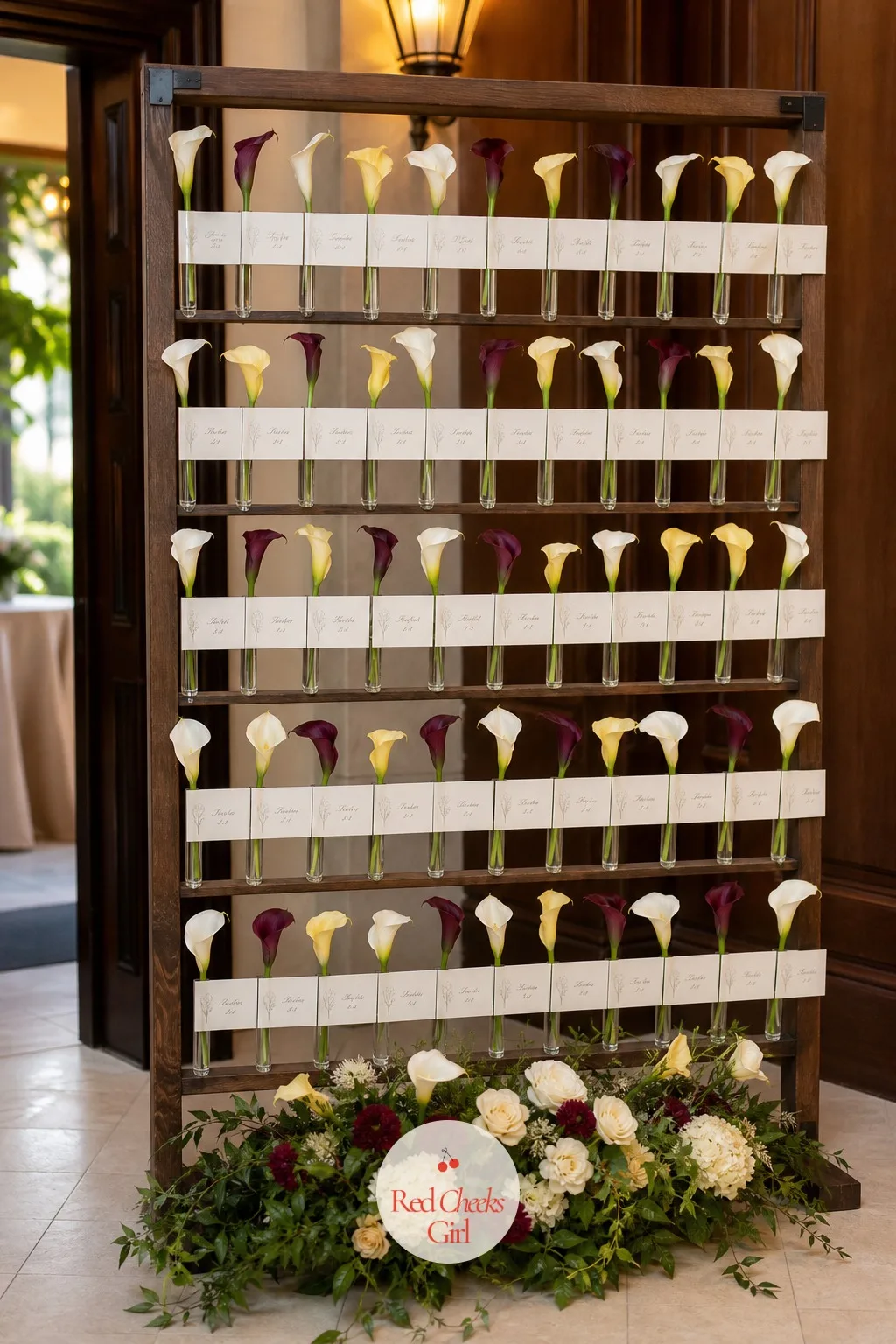 An Escort Card Display on a Calla Lily Wall — Near the entrance to the reception, a standing wall holds escort cards among real calla stems tucked into small