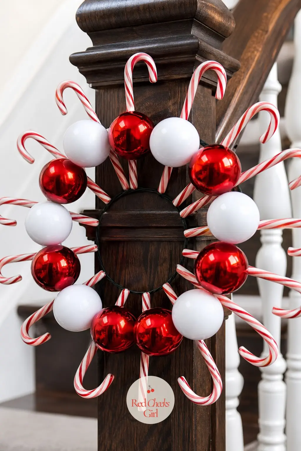 A Shatterproof Ball and Candy Cane Spoke Wreath for the Stairway Newel Post — Glossy red and white shatterproof ornament balls alternate with slim plastic