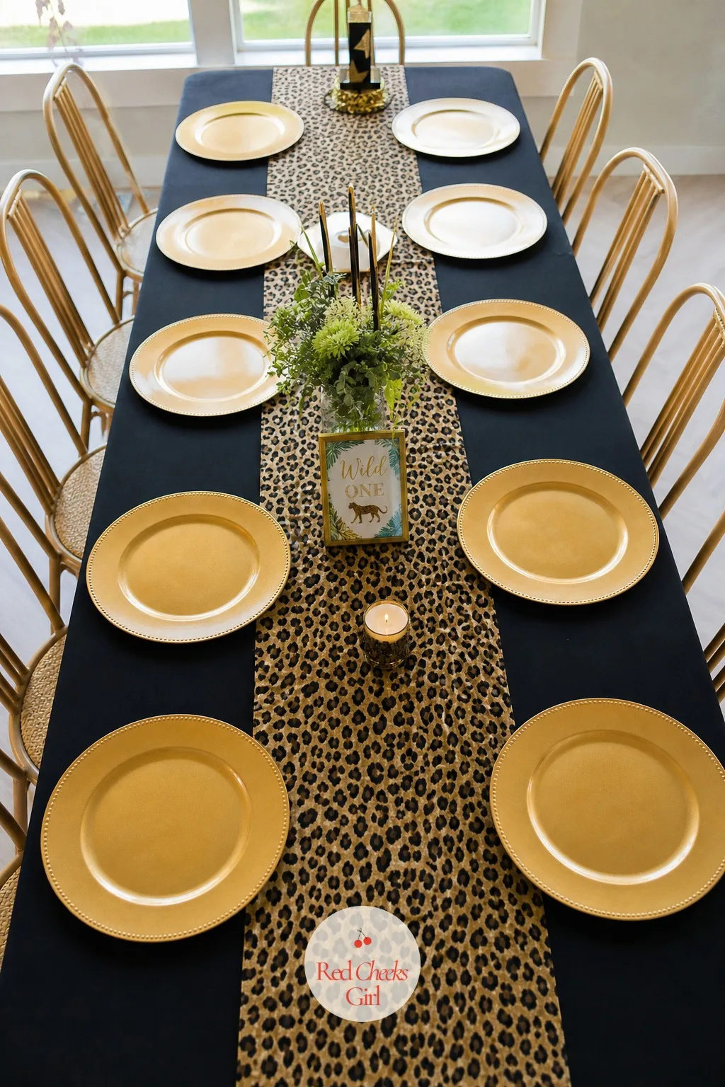 Black and Leopard Print Tablecloth Under Gold Chargers — A bare table says nothing before the food even arrives. Cheetah print birthday party ideas