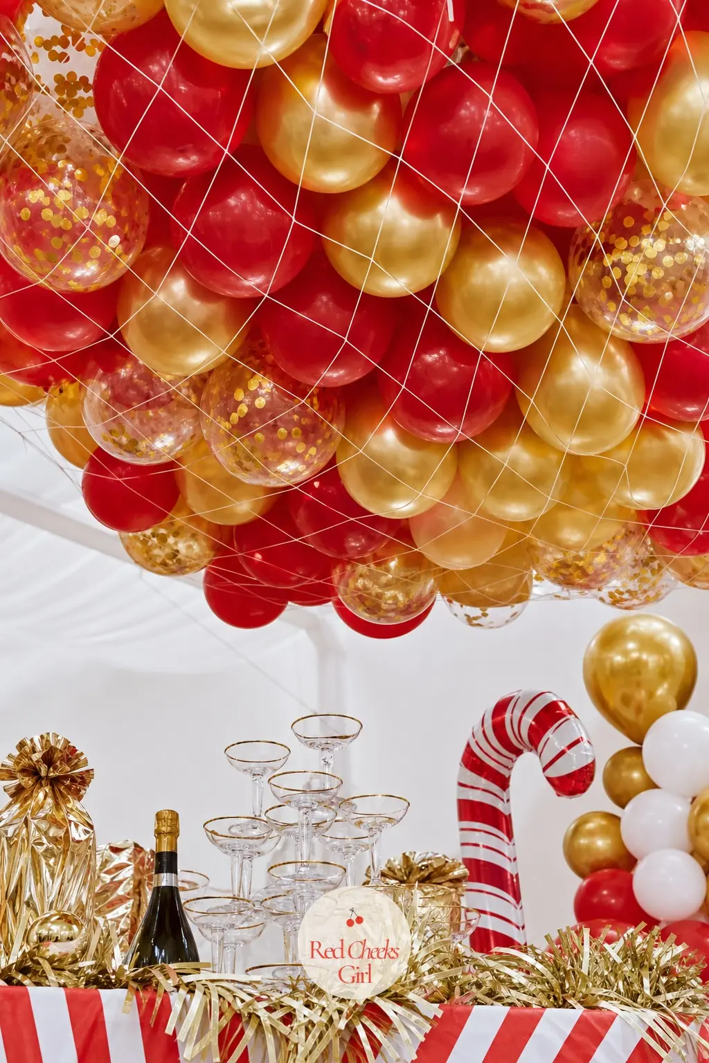 A Balloon Drop Net Loaded Above the Toast Table — A mesh net packed with gold and red balloons hangs ready above the table set for a midnight toast, released