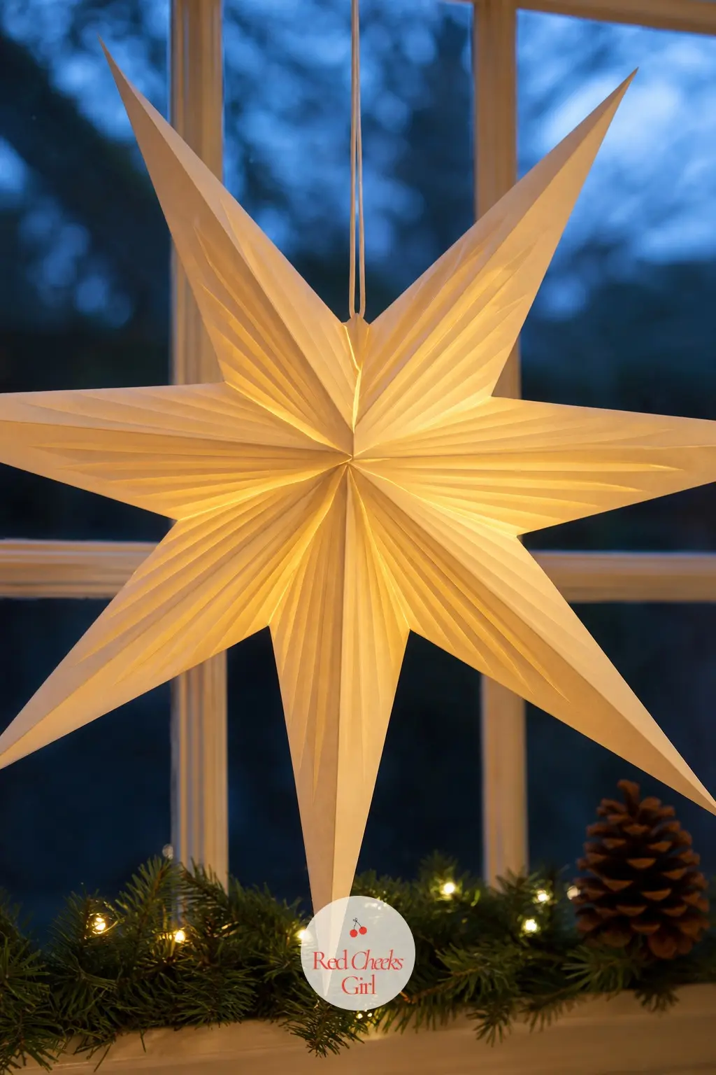 A Folded Paper Star Lantern Glowing in the Window — A single pleated paper star, the kind with a bulb inside rather than a candle, hung in the centre of the