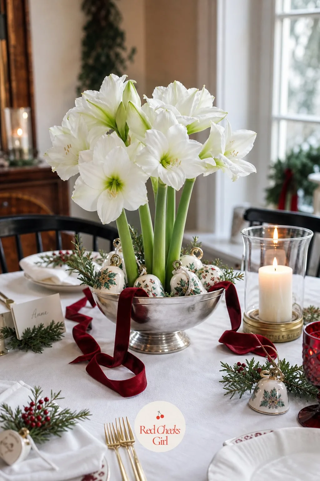 A Low Centerpiece of White Amaryllis and Painted Ceramic Bells in a Silver Bowl — If greenery feels like a repeat of the tree already filling the corner