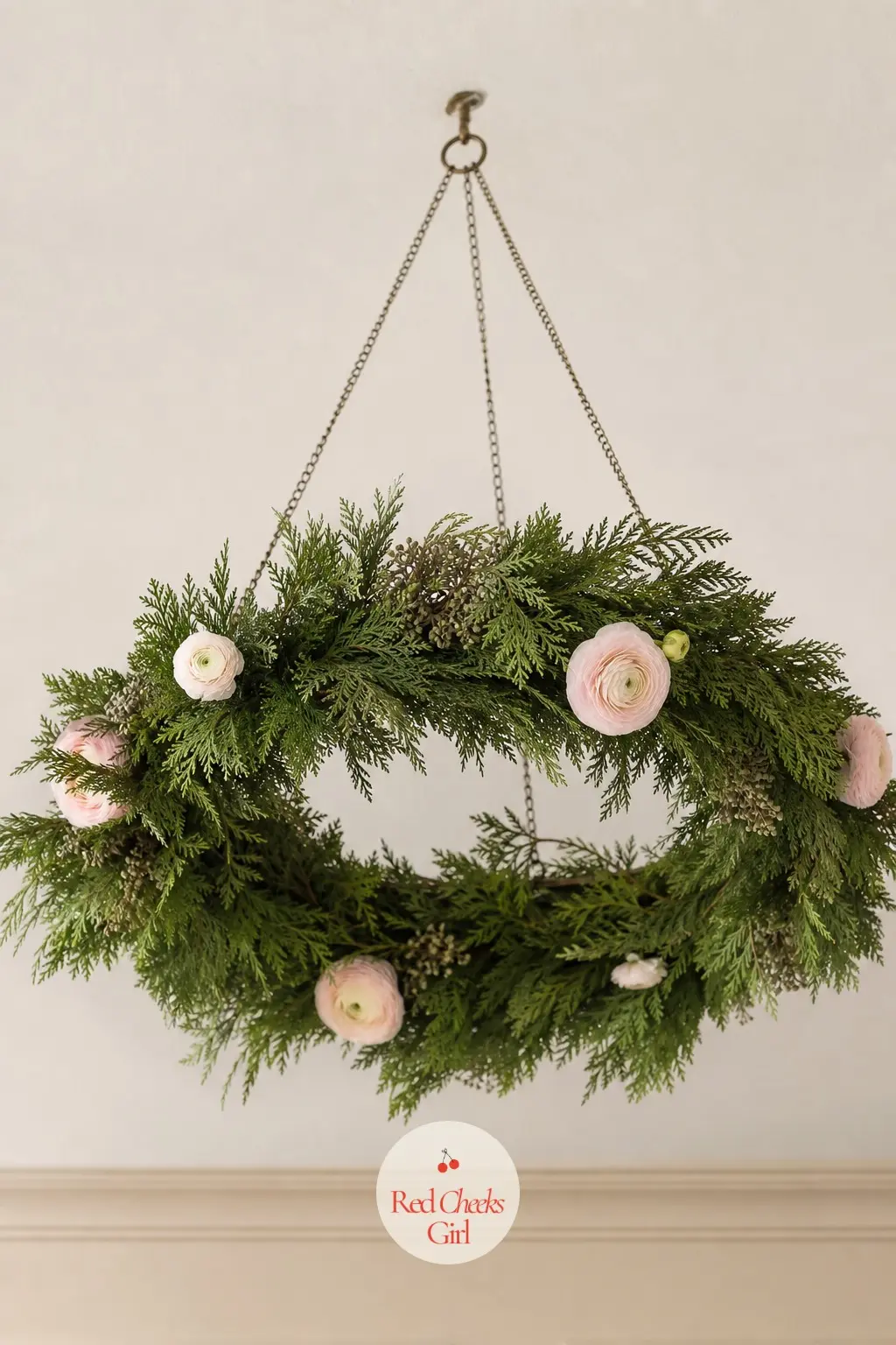 A Hoop Chandelier of Cedar Sprigs and Blush Ranunculus Hung Above the Sofa — Wire fresh cedar sprigs around a plain metal hoop until it is fully covered, then