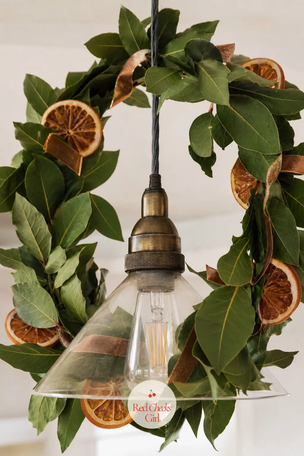 A Ring of Fresh Bay Leaf and Dried Clementine Garland Circling the Pendant Light — Wind fresh bay leaf garland twice around the flex of the dining room