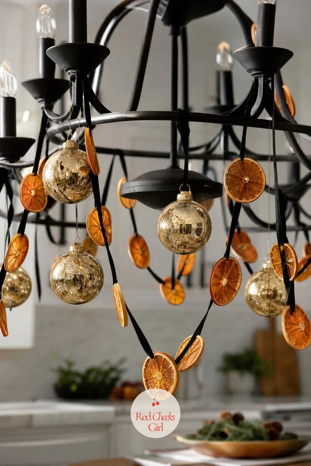 Gold Bauble and Dried Citrus Black Iron Chandelier — Black iron chandeliers read moody on their own, so brighten one over the kitchen table with gold glass