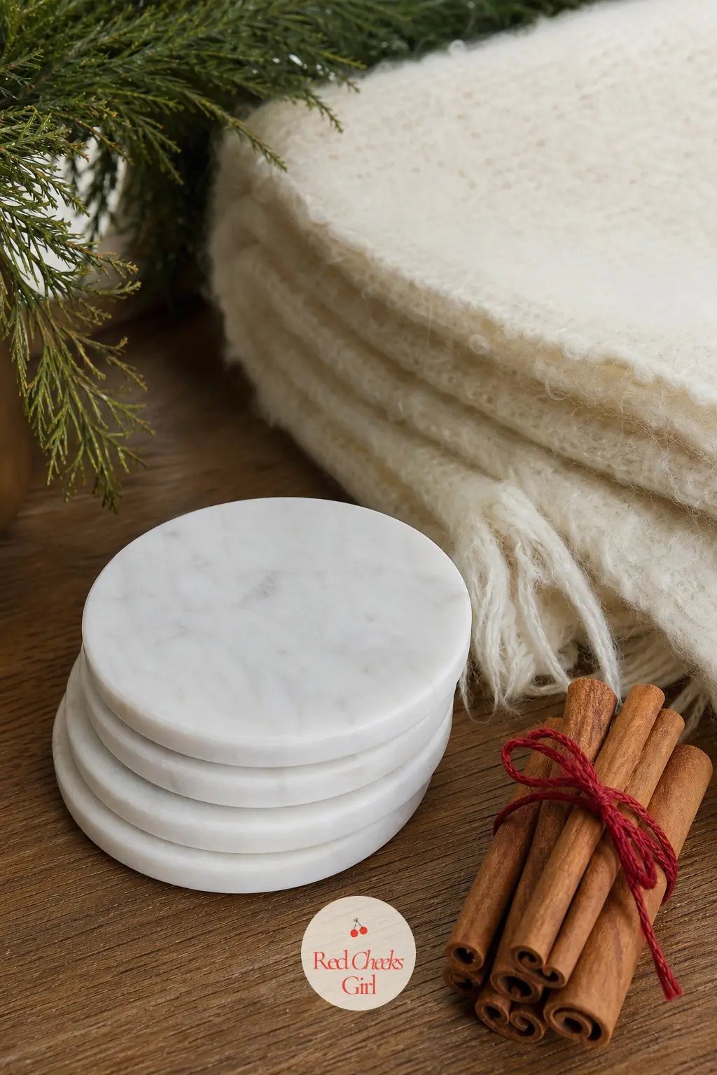 Stacked Marble Coasters Beside a Mohair Throw Square and Cinnamon Bundle — A short stack of round white marble coasters sits beside a folded square of cream