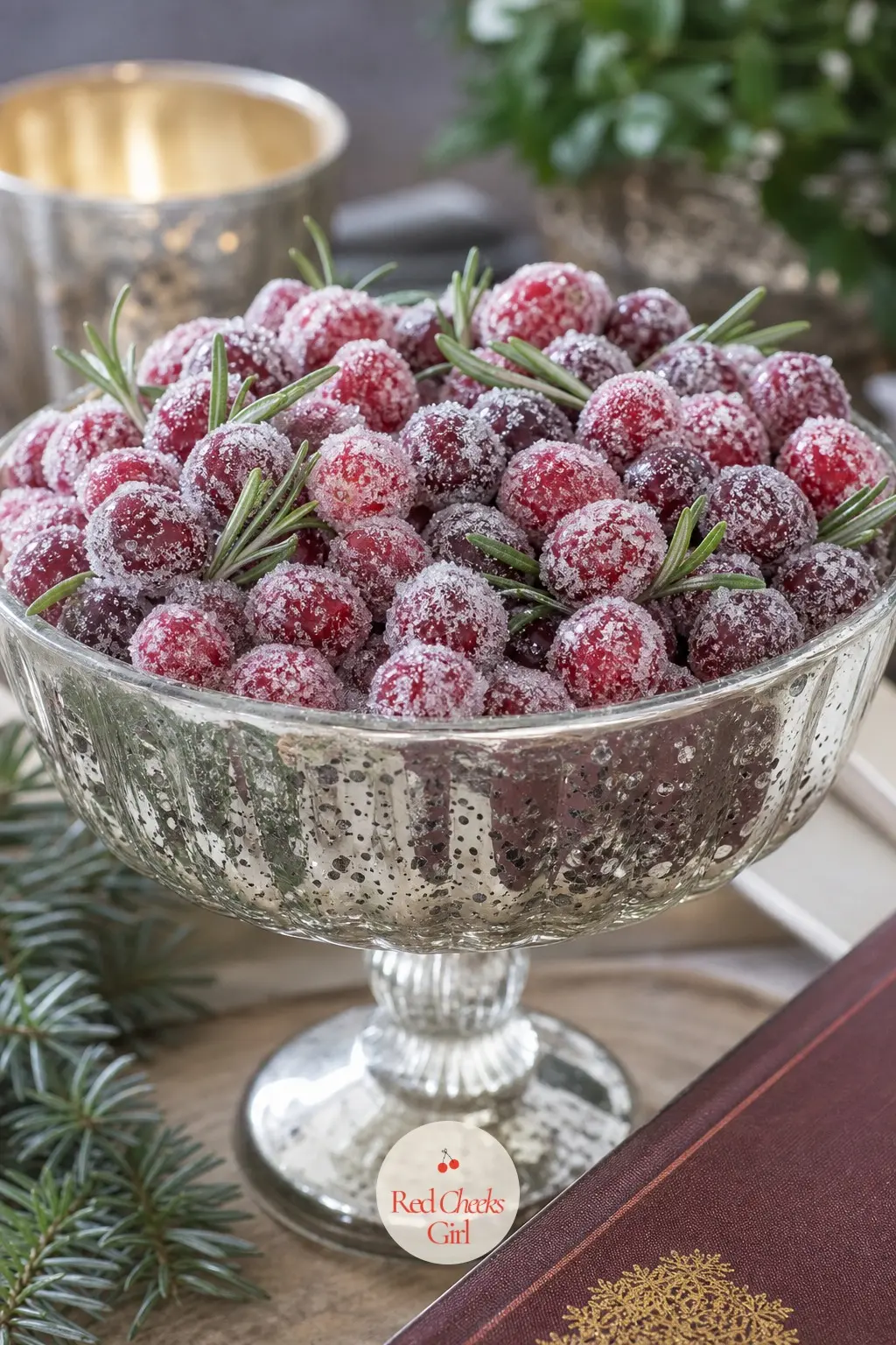A Vintage Mercury Glass Compote Piled With Sugared Cranberries and Rosemary — A footed mercury glass compote holds a loose pile of sugared cranberries with a