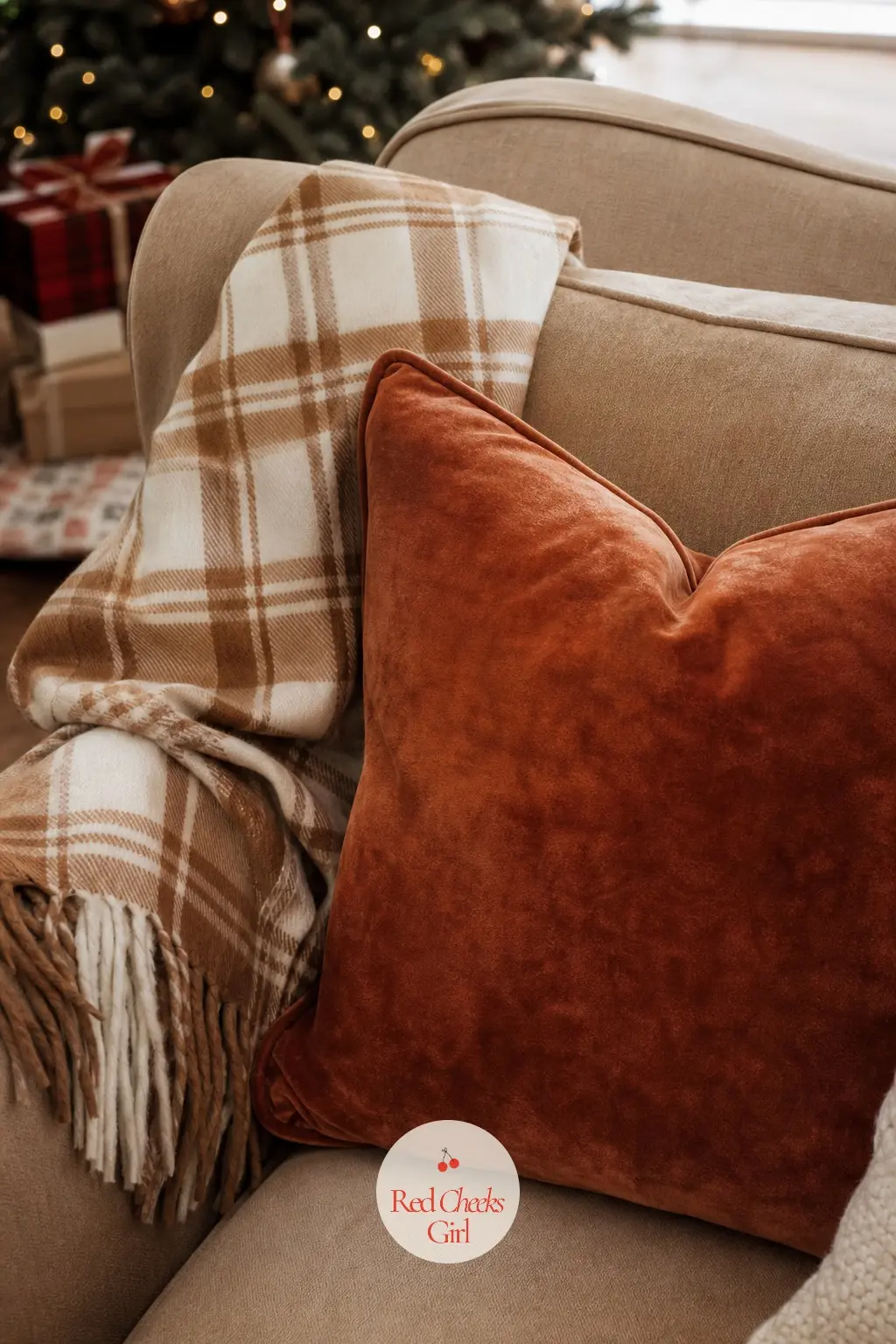 A Burnished Copper Velvet Pillow with a Camel Plaid Throw — A camel and cream plaid throw folds over the arm with one burnished copper velvet pillow set in