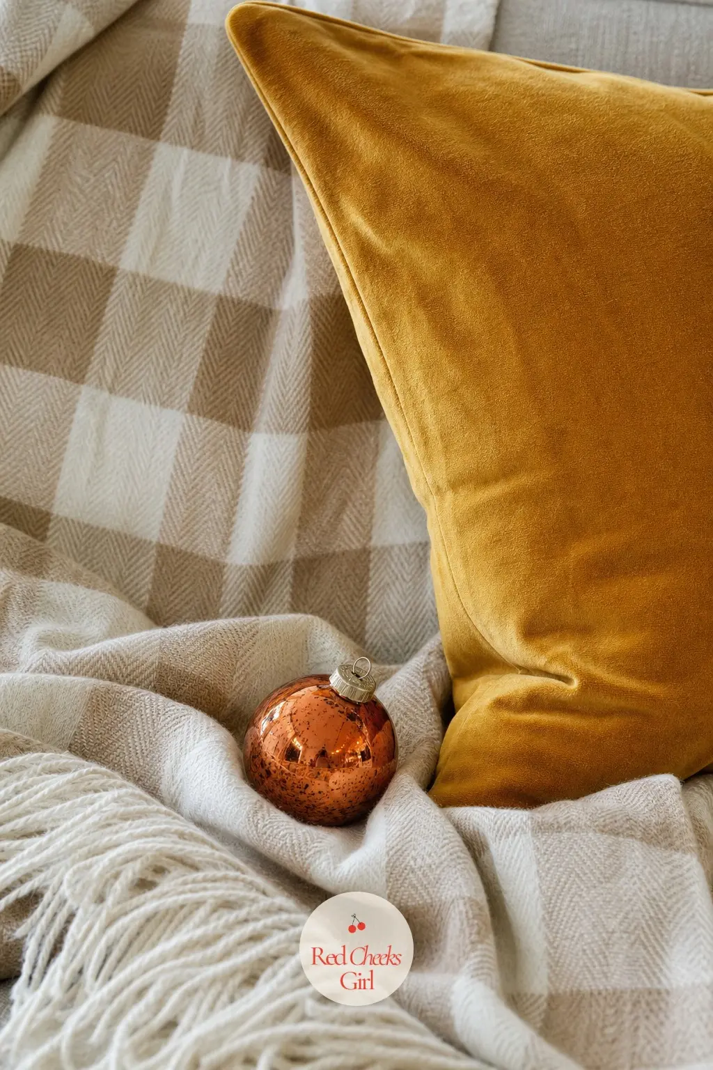 A Mustard Velvet Pillow with a Taupe Buffalo Check Throw and a Copper Bauble — A taupe and cream buffalo check throw, a quieter cousin of the usual red