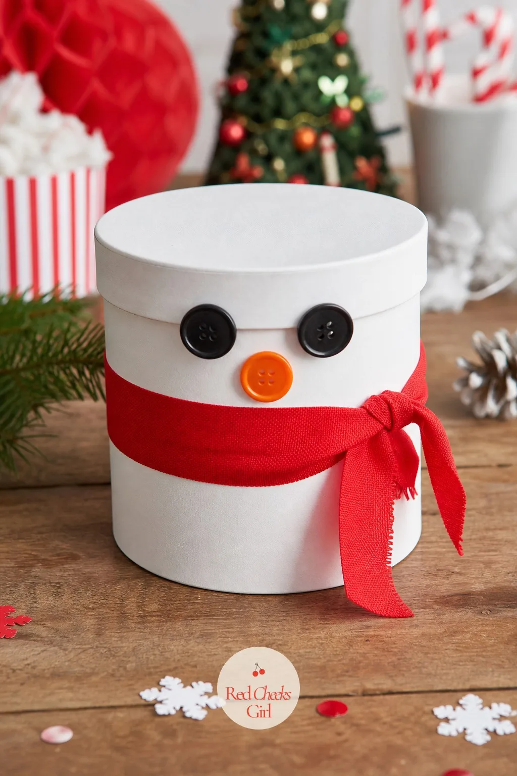 Button Snowman Gift Box — A round white gift box decorated with button eyes and an orange button nose becomes the snowman before it ever gets filled with cocoa