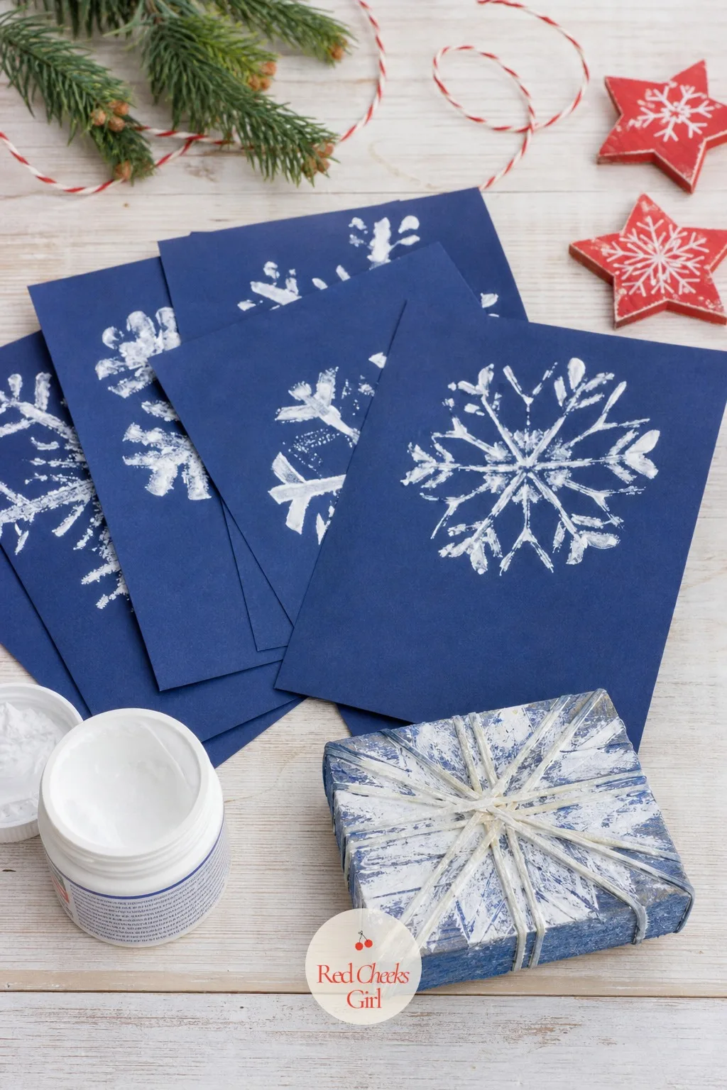 Rubber-Band Snowflake Print Cards — Wrap a handful of rubber bands around a block of wood or a jam jar lid, dip it in white paint, and press it onto navy