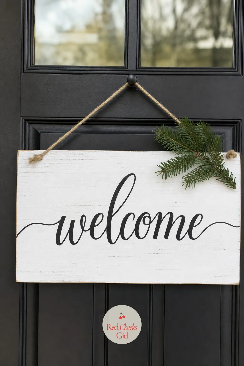 A Hand-Lettered Welcome Sign Hung Where the Wreath Usually Goes — A plain white wood sign, black script reading a short welcome, hangs in the exact center spot