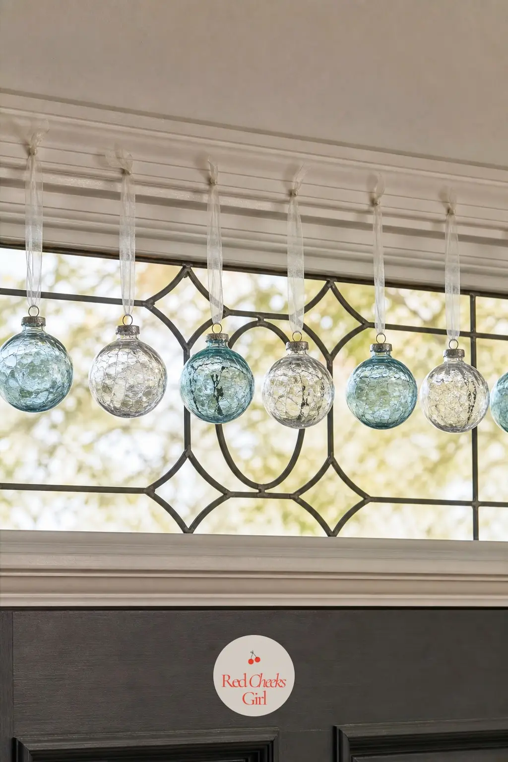 A Single Row of Clear Glass Baubles Strung Across a Transom — A transom window above the door takes a plain fishing line strung horizontally, clear and
