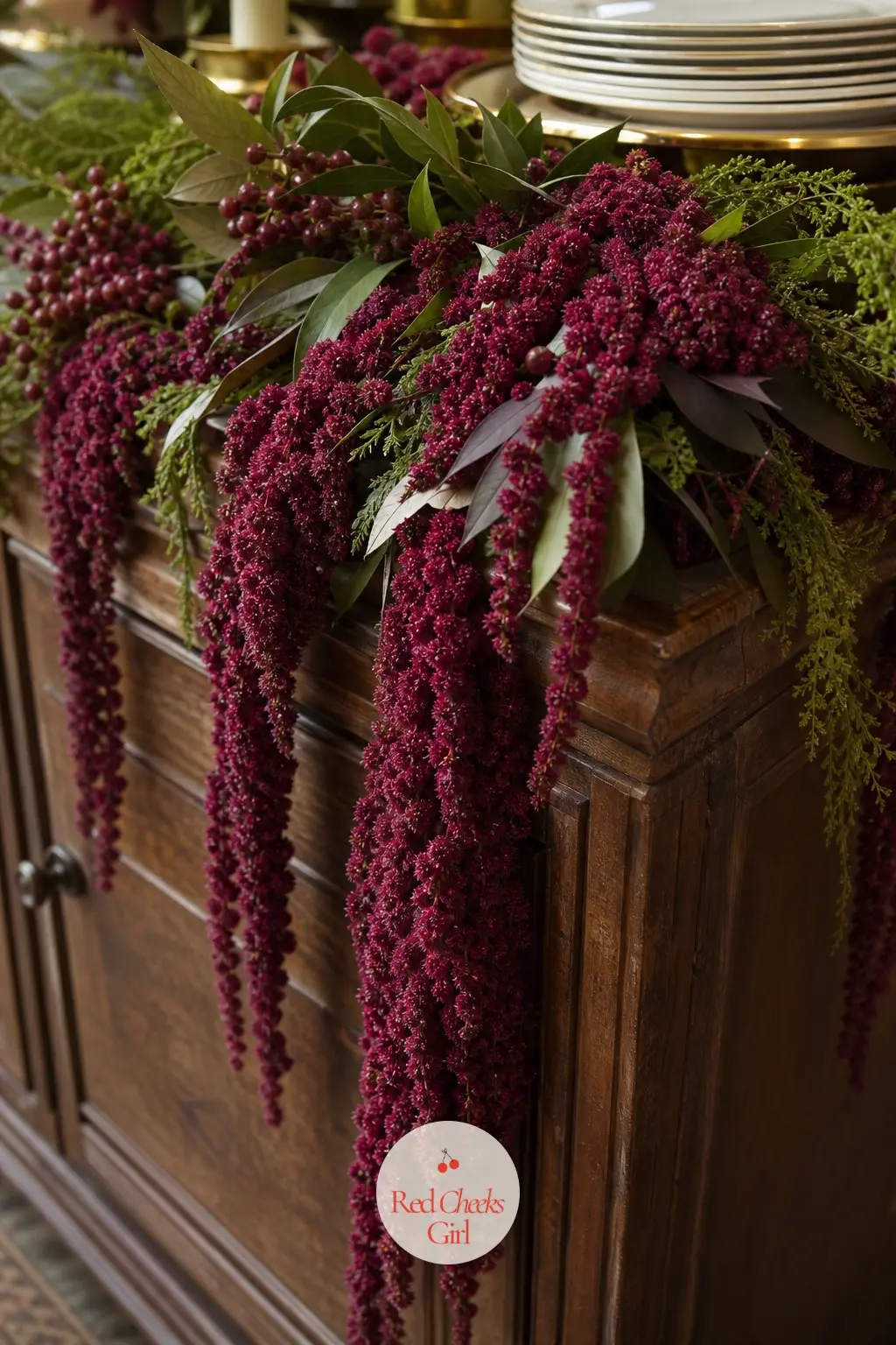 Cascading Burgundy Amaranthus — Trailing burgundy amaranthus spilling over the edge of a buffet sideboard among loose greenery is the most dramatic, moody