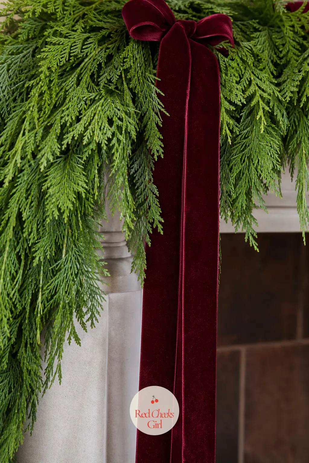 Fresh Cedar With Long Velvet Ribbon Tails — A thick fresh cedar garland along the mantel, finished with two long wine red velvet ribbon tails that drop almost