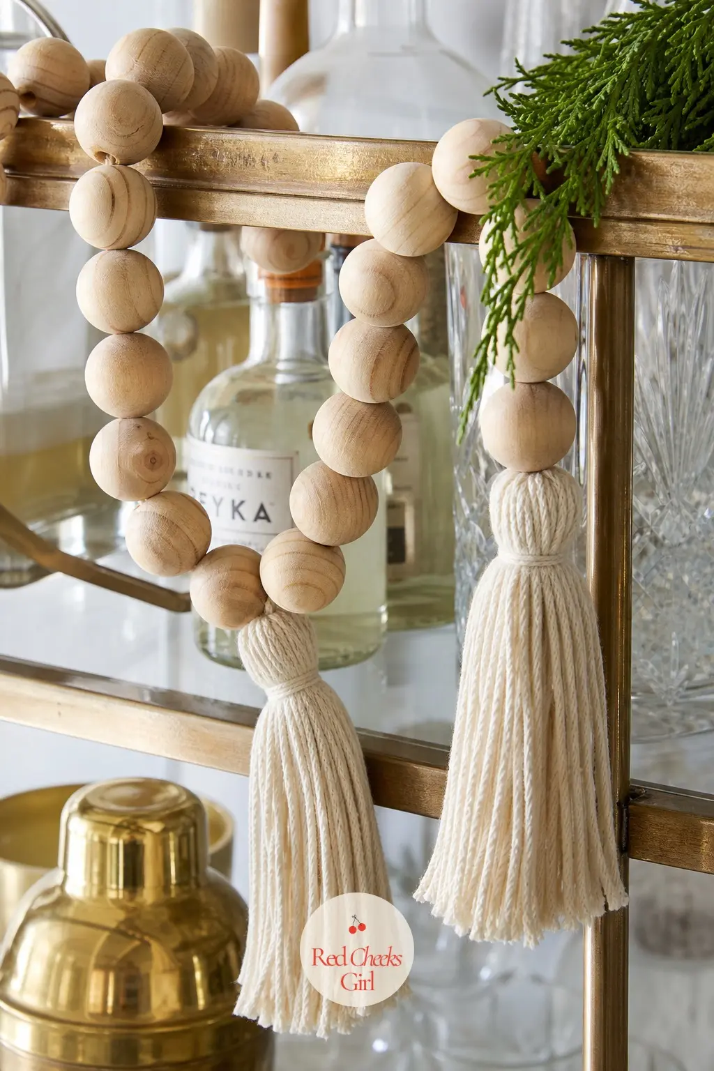 Wooden Bead Garland With Tassels — A natural wooden bead garland finished with cream cord tassels along a bar cart shelf brings a Scandinavian, pared back
