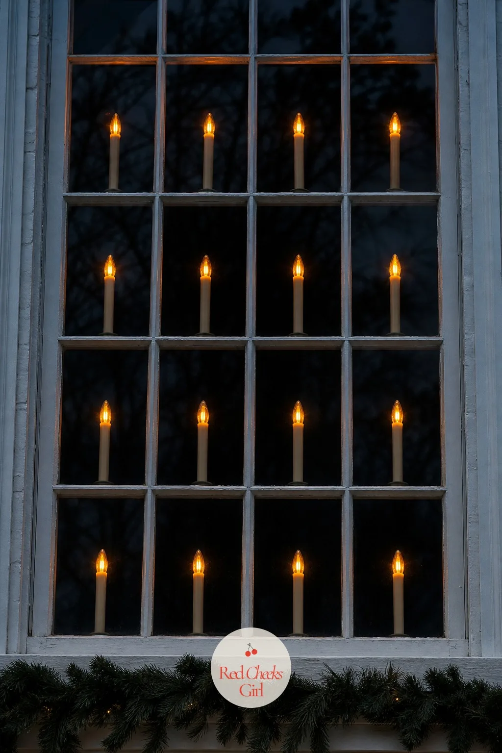 Electric Window Candles in Every Pane — This is the detail the house with the roofline spotlights and the driveway arch somehow forgets, and it is the one that