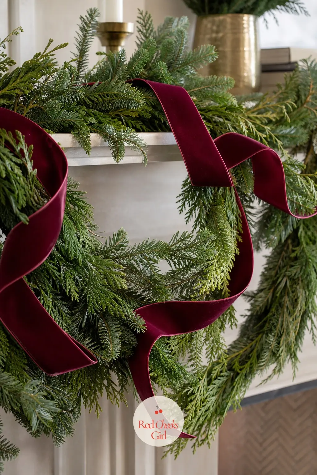 A Burgundy Ribbon Woven Through a Double-Draped Garland — A plain green garland gets a classic lift from one wide ribbon threaded through it in long loops
