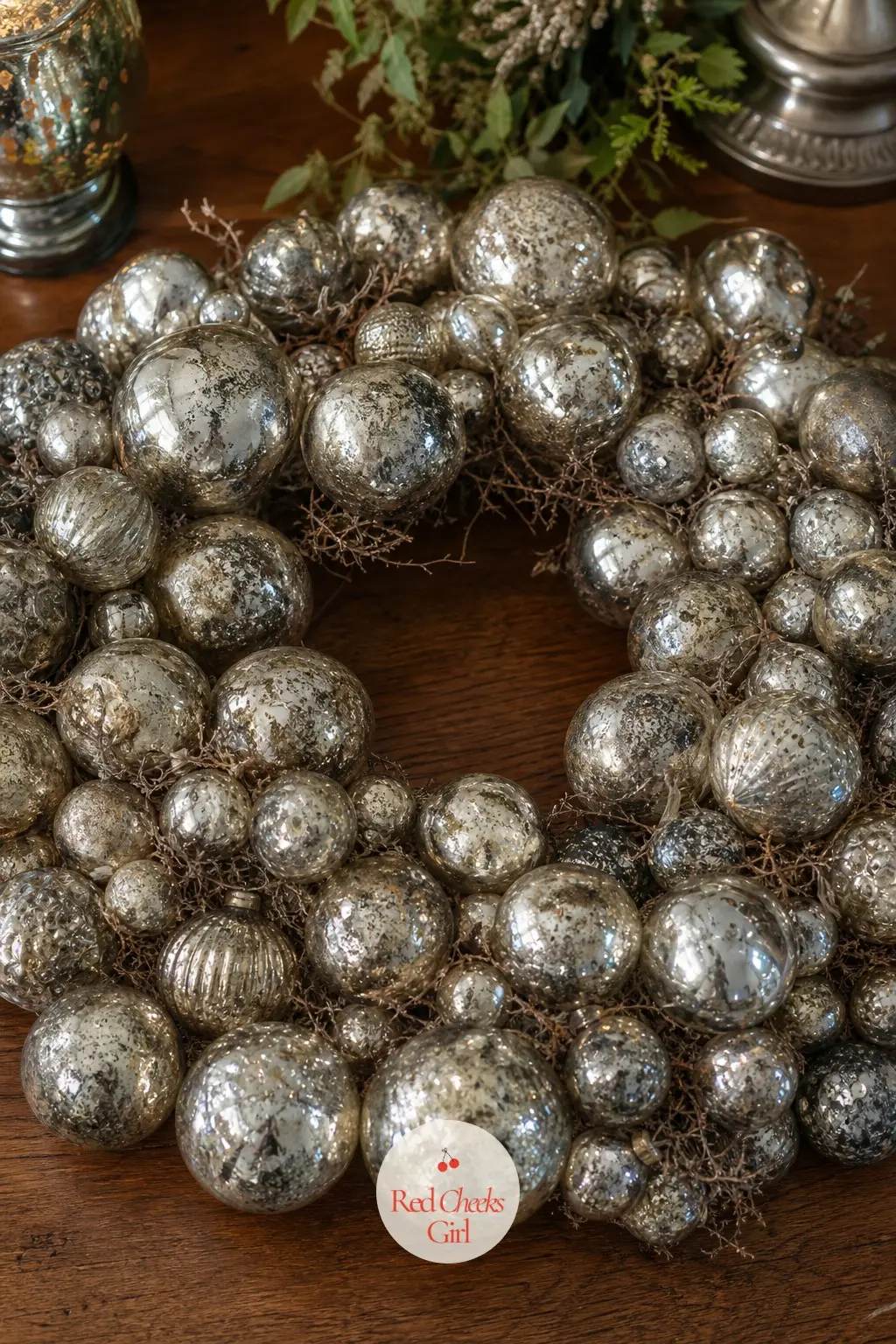 The Mercury Glass and Antique Silver Wreath for the Sideboard — Mercury glass balls carry a cloudy, slightly uneven shine that no new ornament quite fakes, and