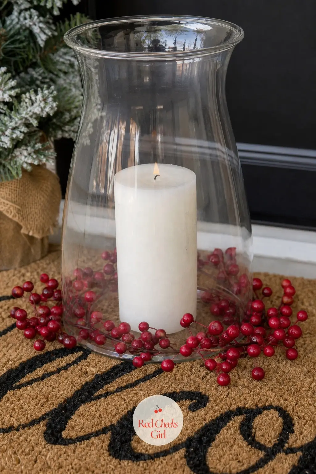 A Clear Glass Hurricane Lantern Centered on the Welcome Mat — Setting one large hurricane dead centre on the mat, rather than off to a side, forces anyone