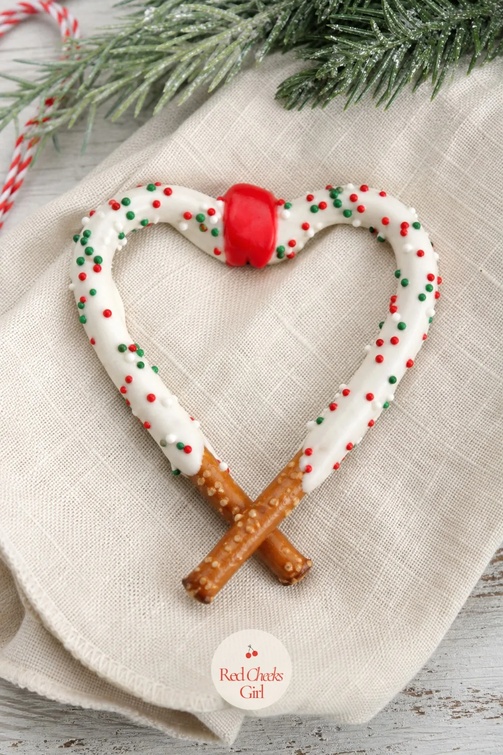 Pretzel Candy Cane Hearts — Two curved pretzel rods, hooked together at the top, make a heart with a candy cane twist. Christmas pretzel treats