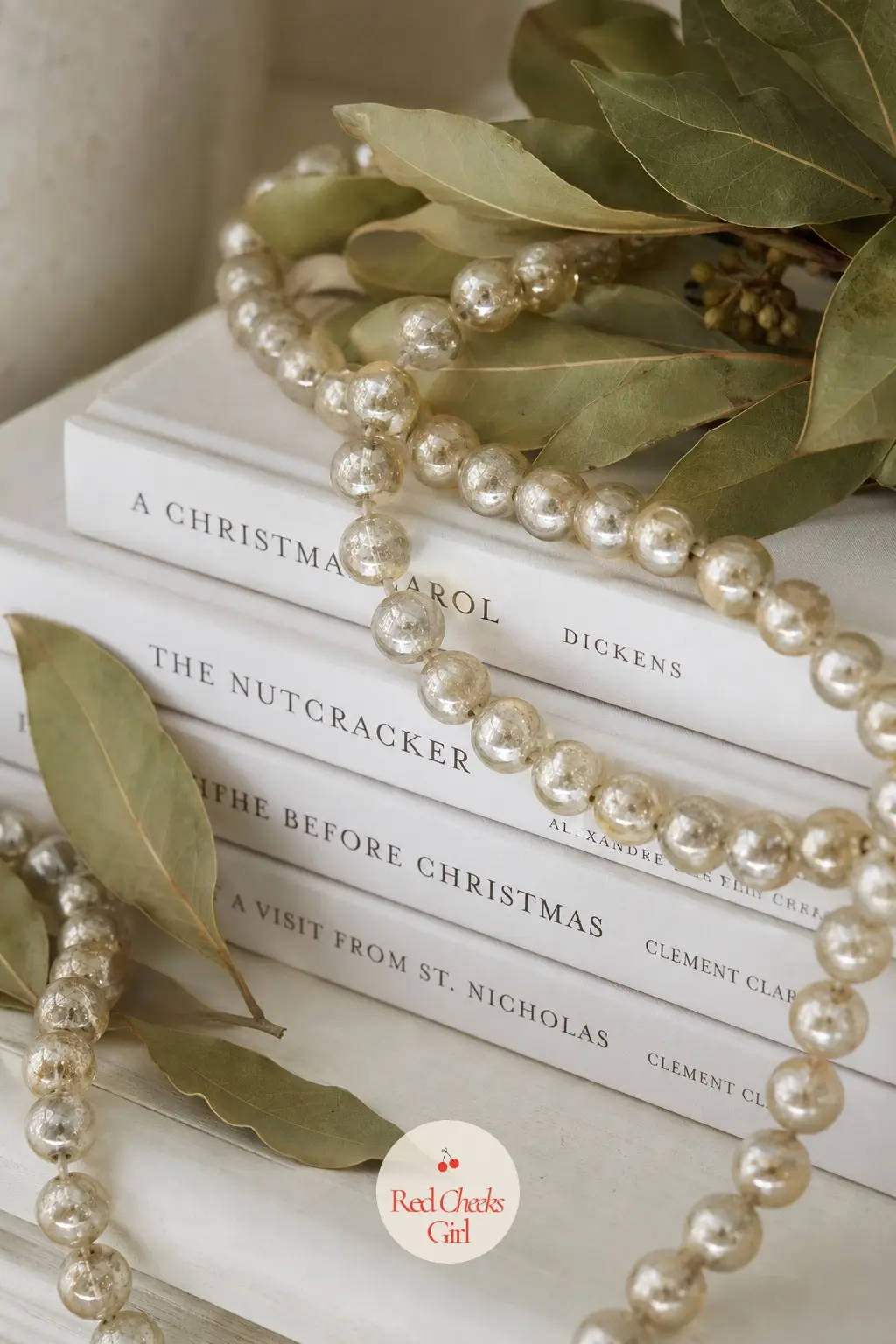 White Spined Books With Bay Leaf and Pale Gold Mercury Beads — Lay white spined books flat and stack them sideways rather than upright, which photographs