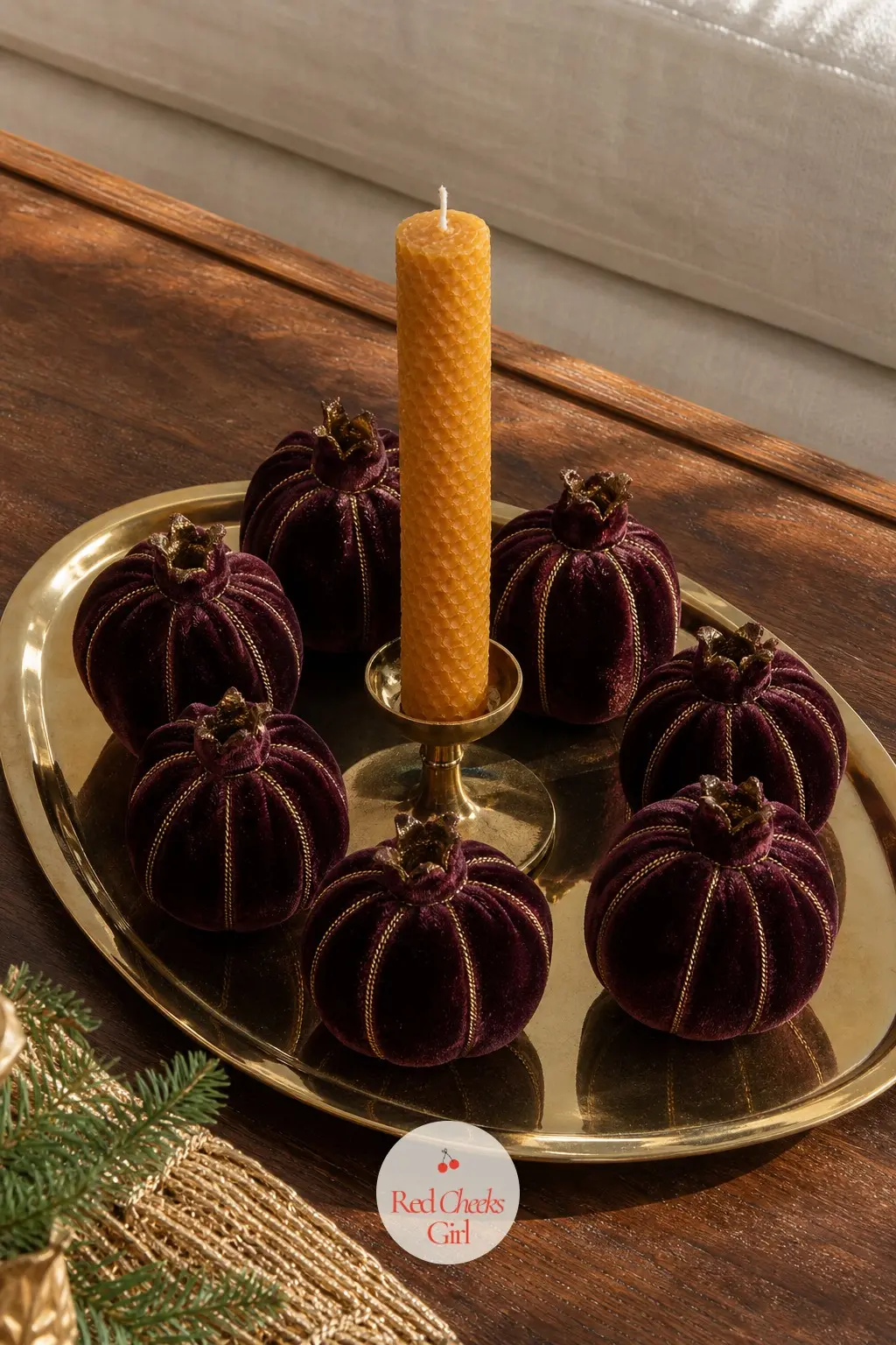 A Brass Oval Tray With Velvet Pomegranates and a Honey Beeswax Taper — Three or four velvet pomegranates in deep plum pile loosely around a single squat