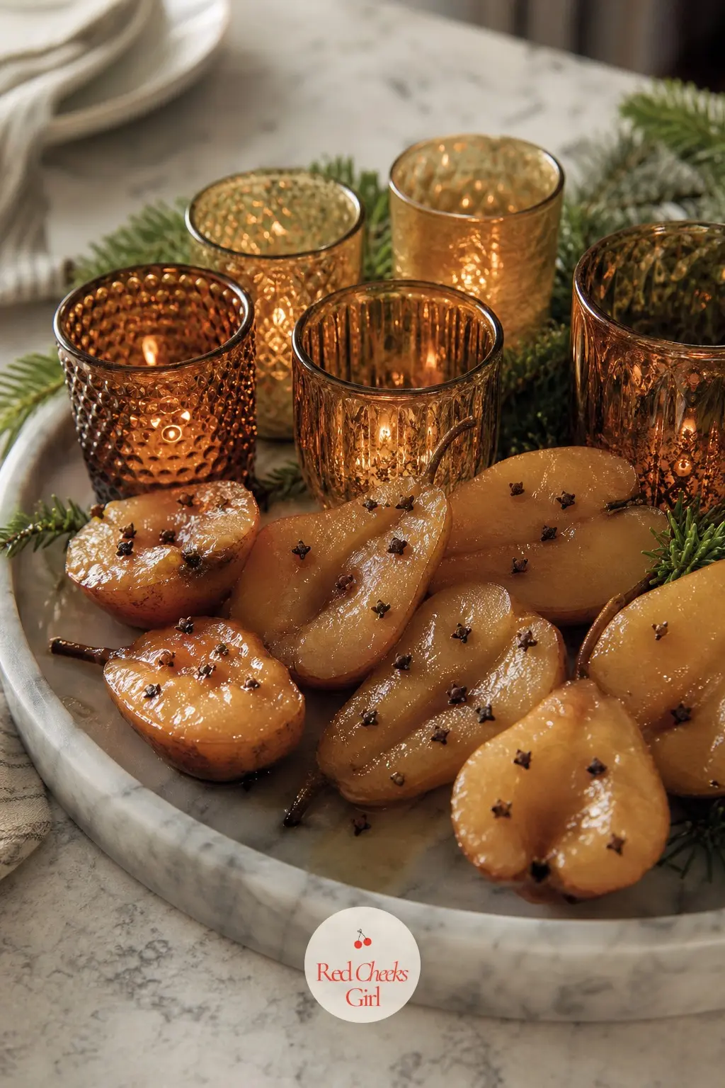 A Marble Tray of Spiced Pear Halves and a Cluster of Amber Votives — Real or faux pear halves studded with a few whole cloves sit beside a cluster of amber