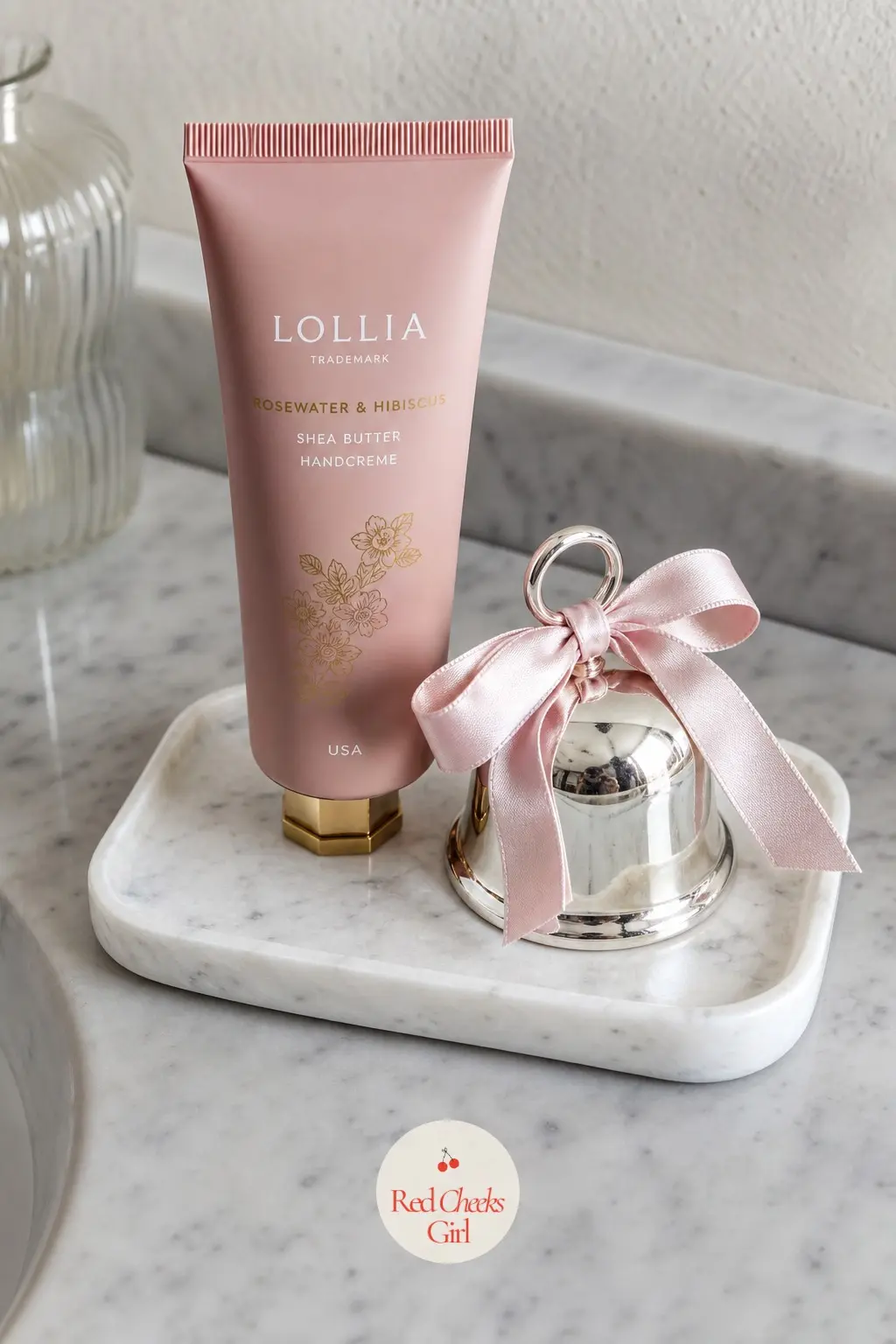 A Marble Vanity Tray of Rosewater Hand Cream and a Tiny Silver Bell — A small marble vanity tray holds a bottle of rosewater hand cream in dusty rose packaging