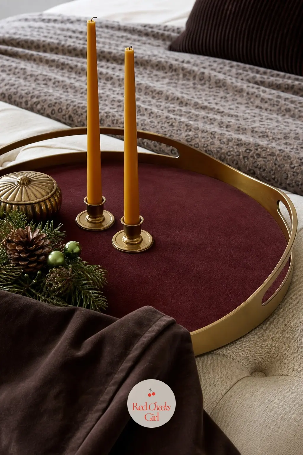 A Velvet Topped Ottoman Tray With Mustard Tapers and a Chocolate Suede Corner — Two mustard taper candles rise from a velvet topped ottoman tray, with the