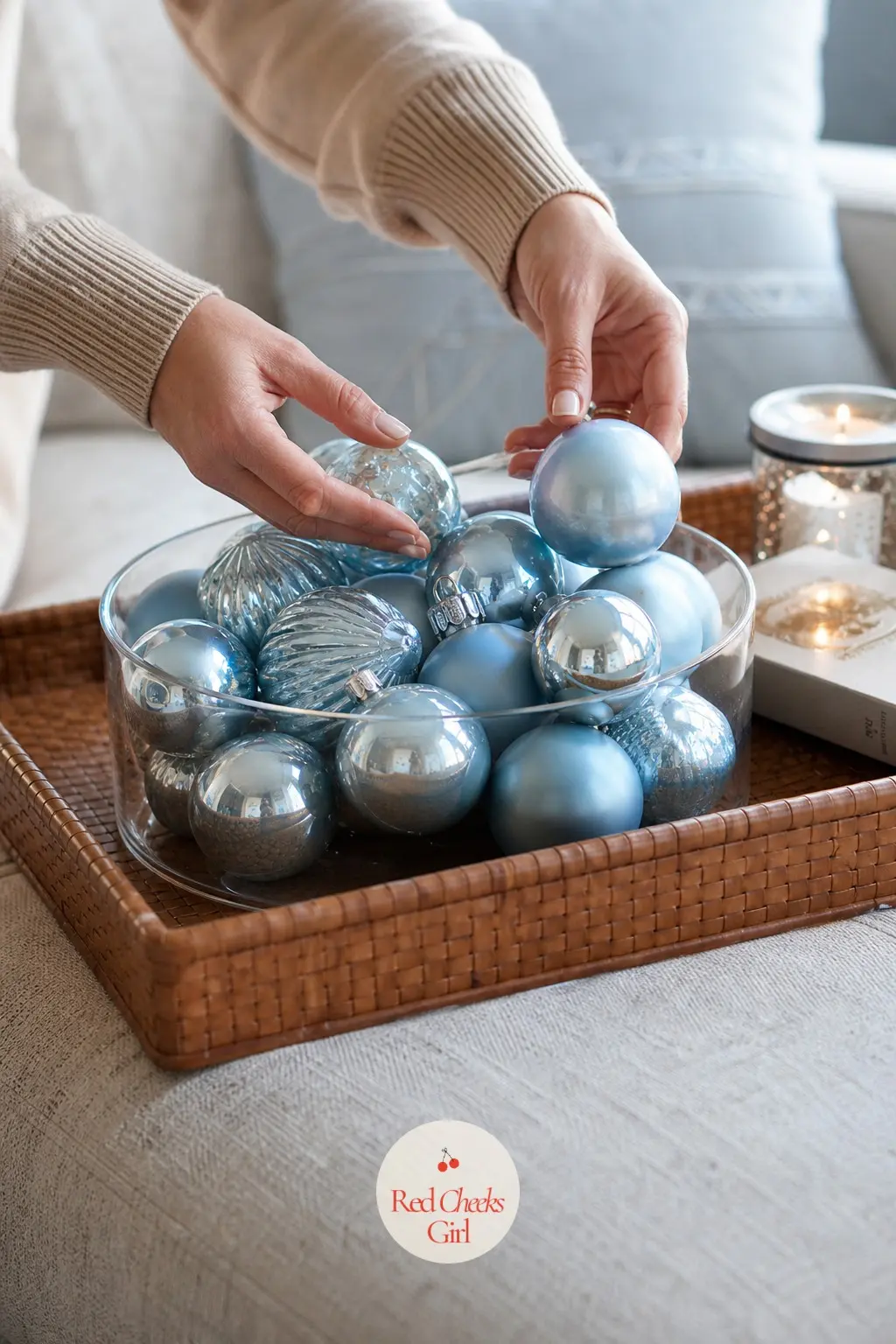 A Woven Leather Ottoman Tray of Powder Blue Glass Baubles in a Low Bowl — A low glass bowl filled with powder blue glass baubles sits in the centre of a woven